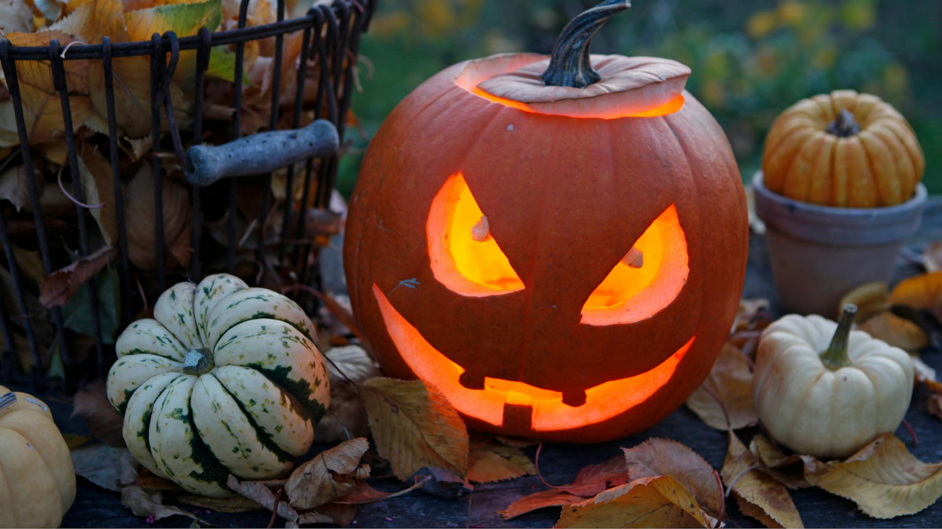 Una zucca illuminata dall’interno con volto inquietante situata all’aperto.
