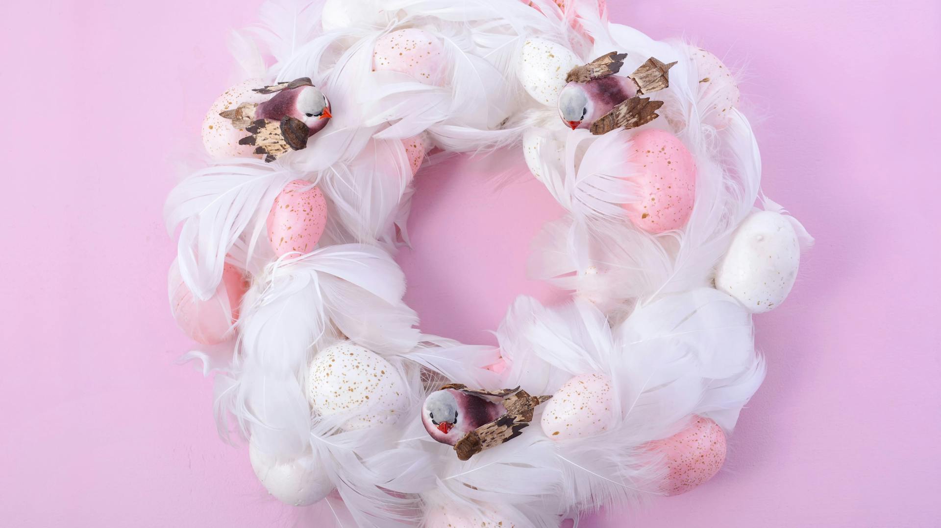 Osterkranz mit weißen Federn und rosa Eiern