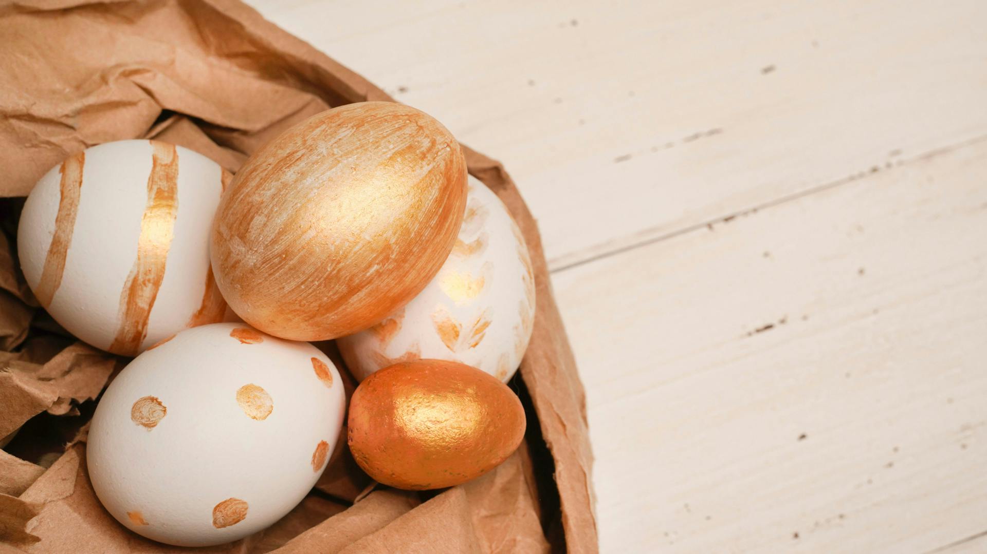 Orangefarbenes Osternest aus Papier mit bunten Eiern