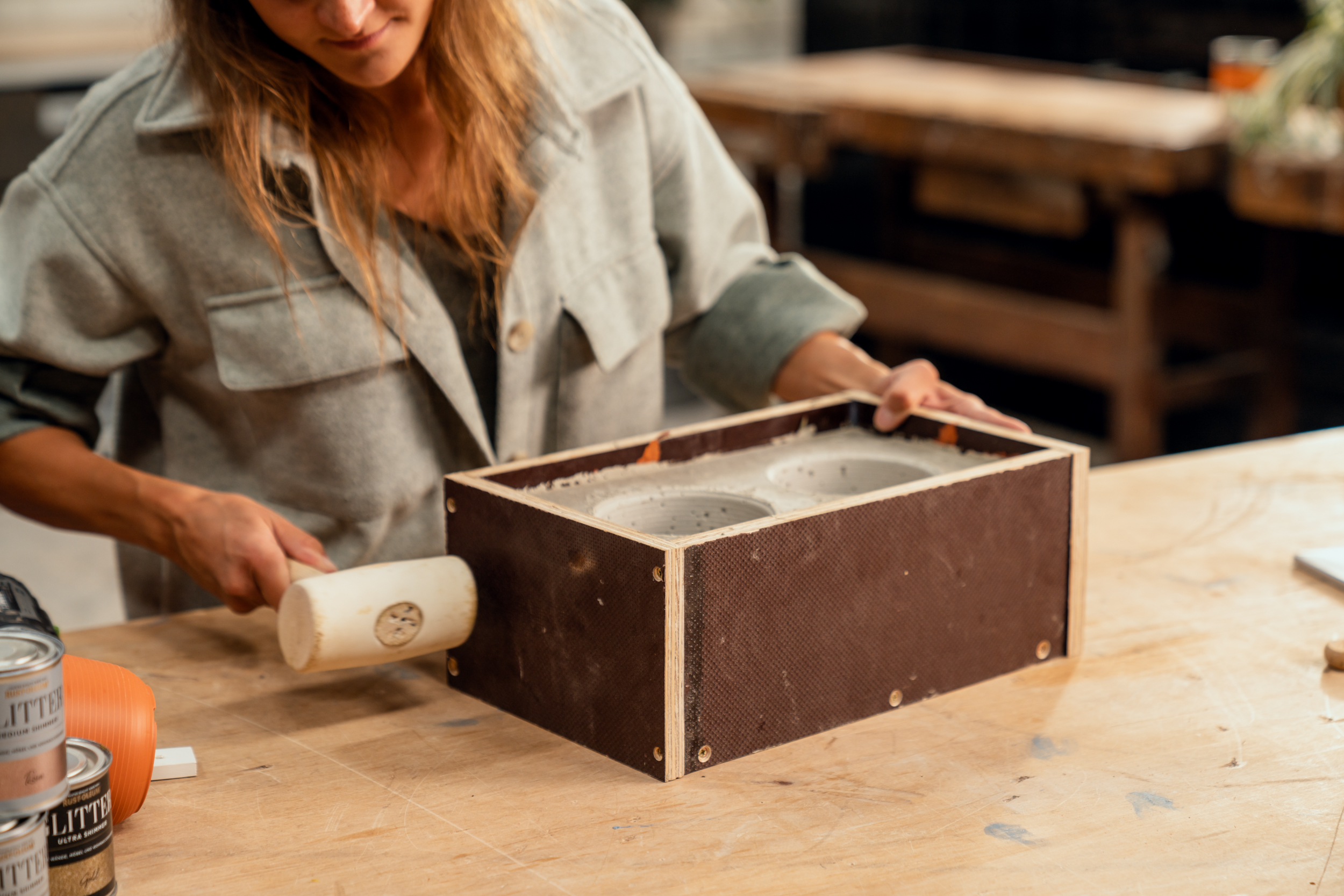 Kalapáccsal ütögetnek egy betonnal teli fadobozt