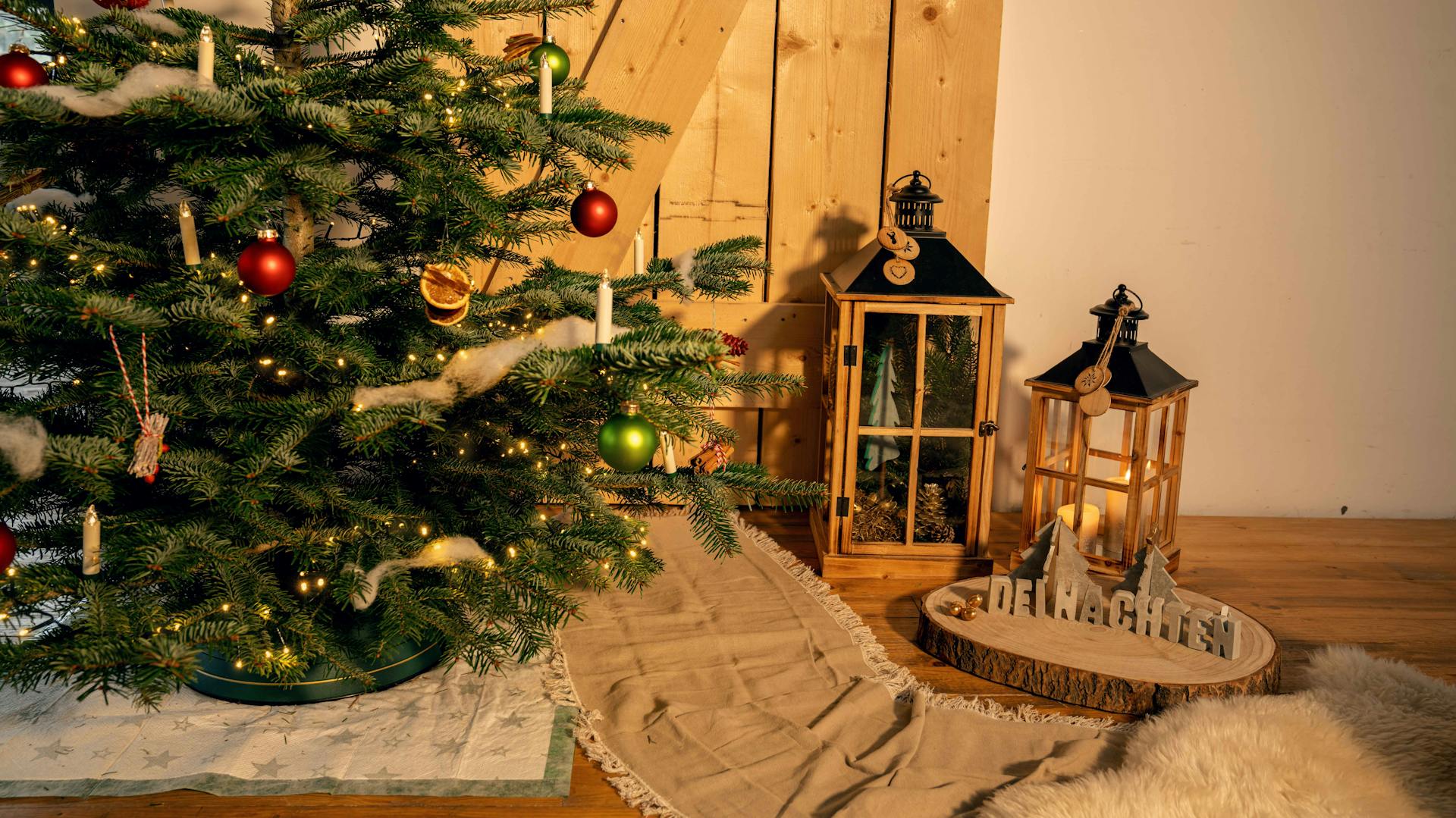 Aufgestellter Weihnachtsbaum auf Decke neben Laternen