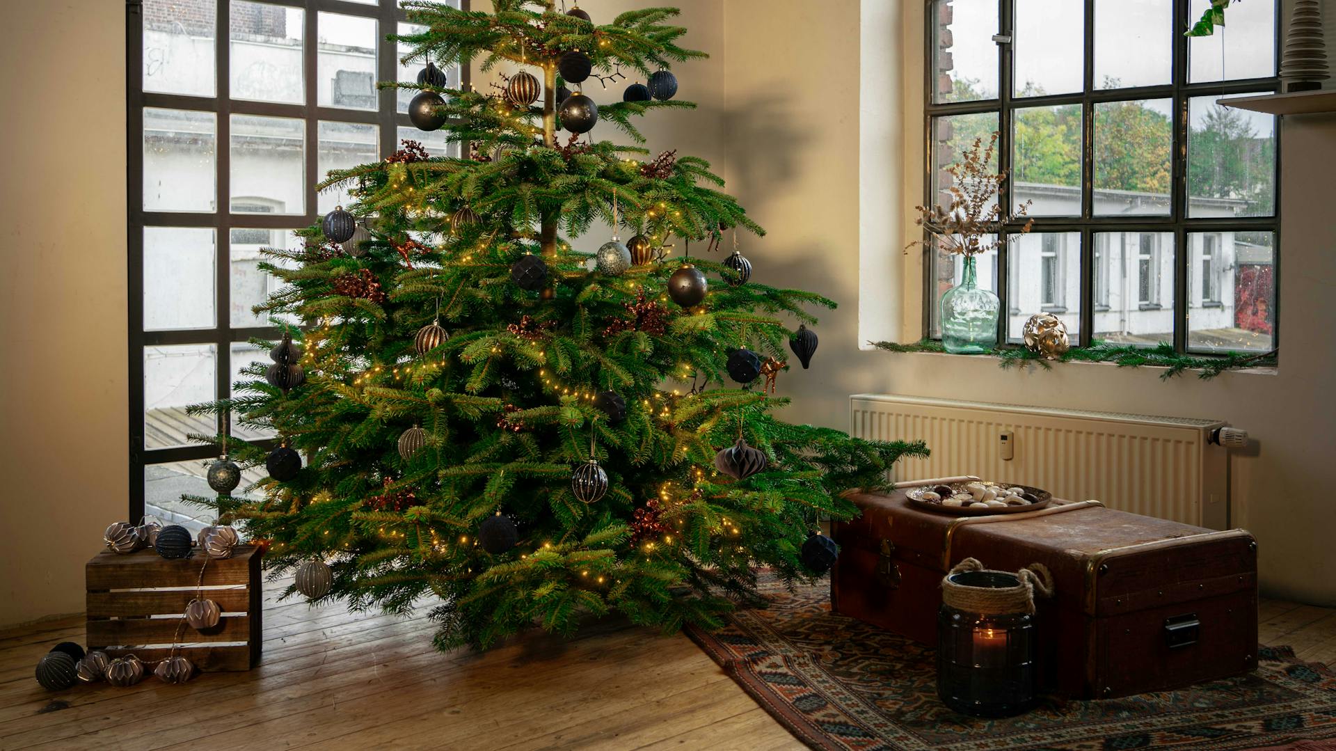 Nemes karácsonyfa kék gömbökkel az ablak előtt