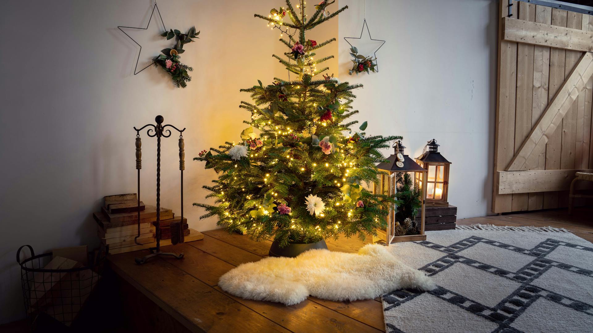 Díszített és kivilágított fa virágdíszekkel a nappaliban