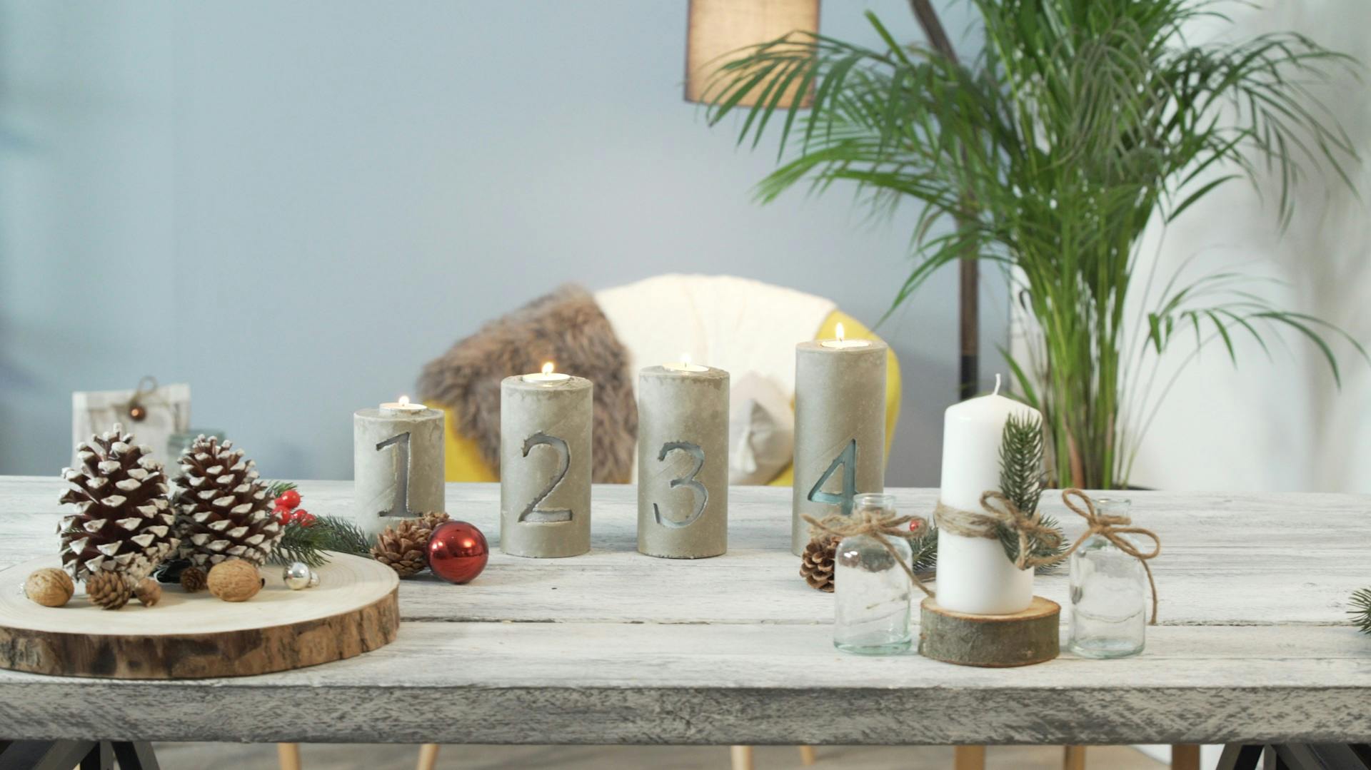 Quattro portacandela di calcestruzzo contrassegnati con i numeri da 1 a 4.