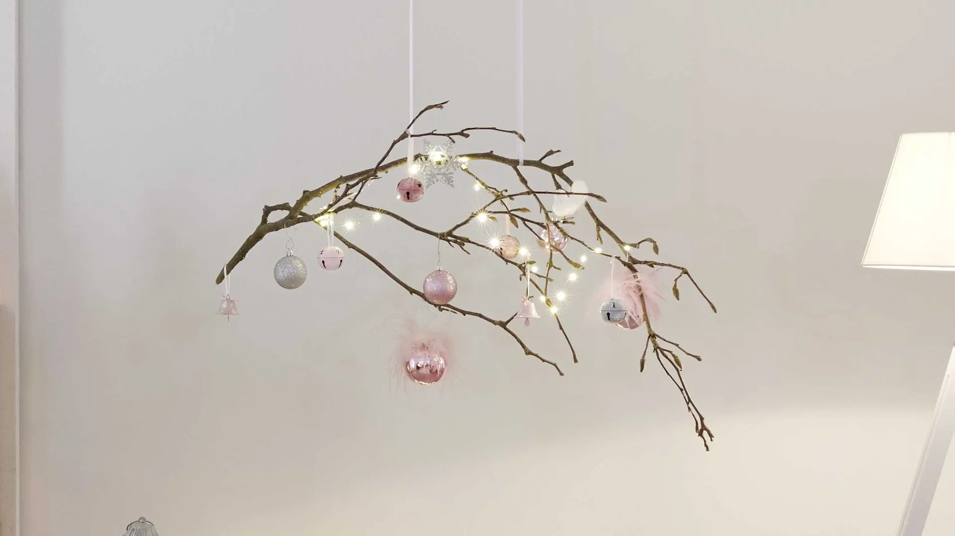 Ramoscello decorativo con palline in rosa tenue come idea decorativa natalizia intorno all’albero di Natale