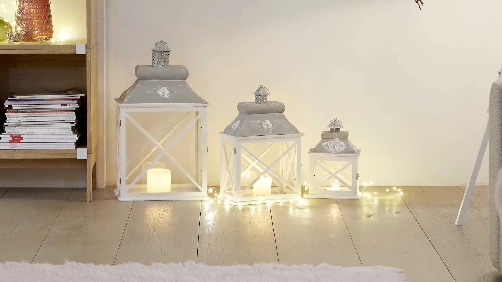 Lanterne bianche come idea per decorazioni natalizie intorno all’albero di Natale