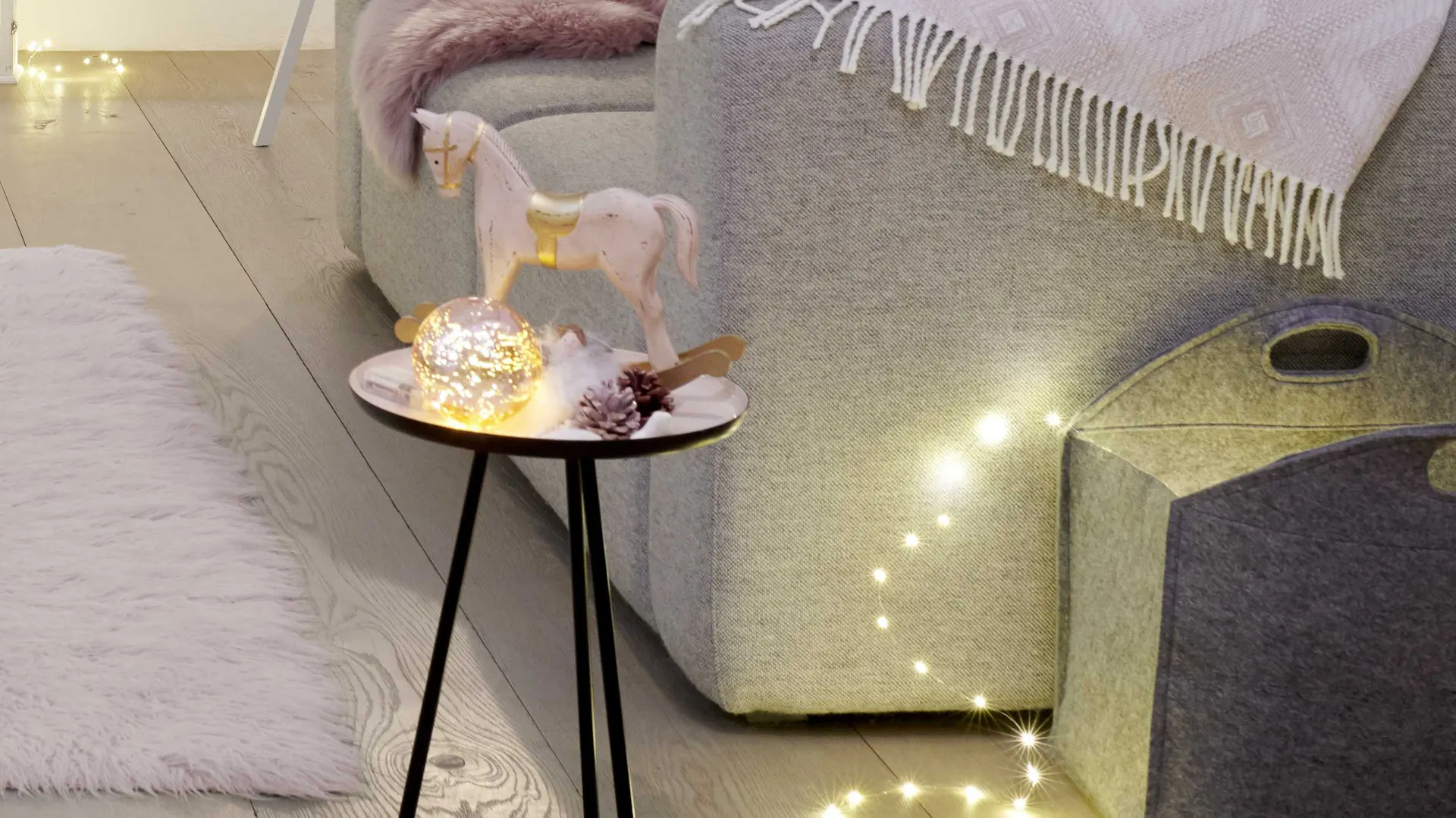 Decorazioni natalizie in rosa tenue: figura decorativa di cavallo a dondolo su un tavolo da appoggio