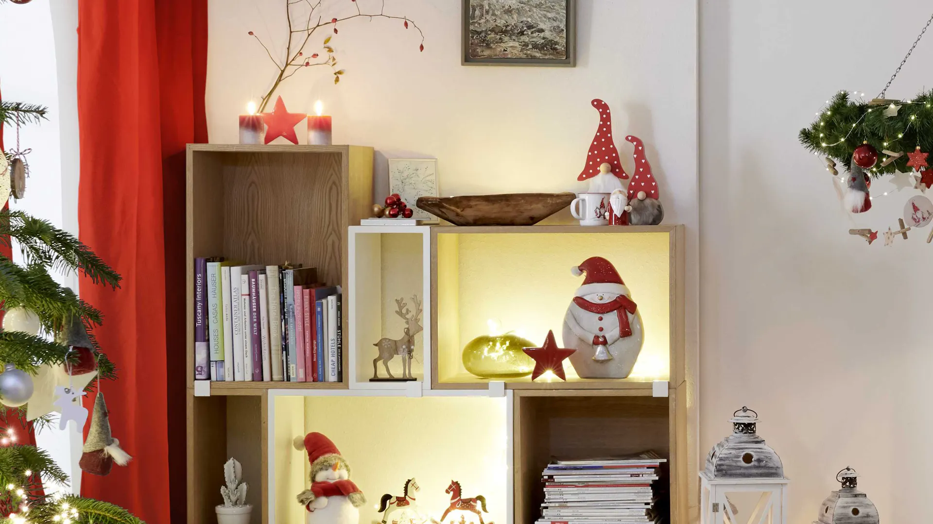 Scaffale illuminato con figure decorative natalizie come pupazzo di neve, gnomo e cavallo a dondolo