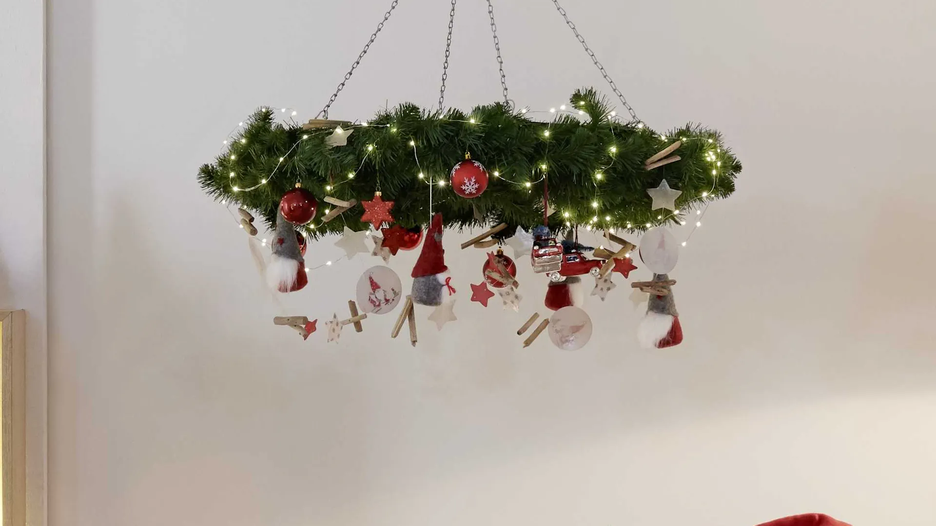 Ghirlanda per il soffitto con ramoscelli d’abete e ghirlanda luminosa come idea decorativa per l’albero di Natale