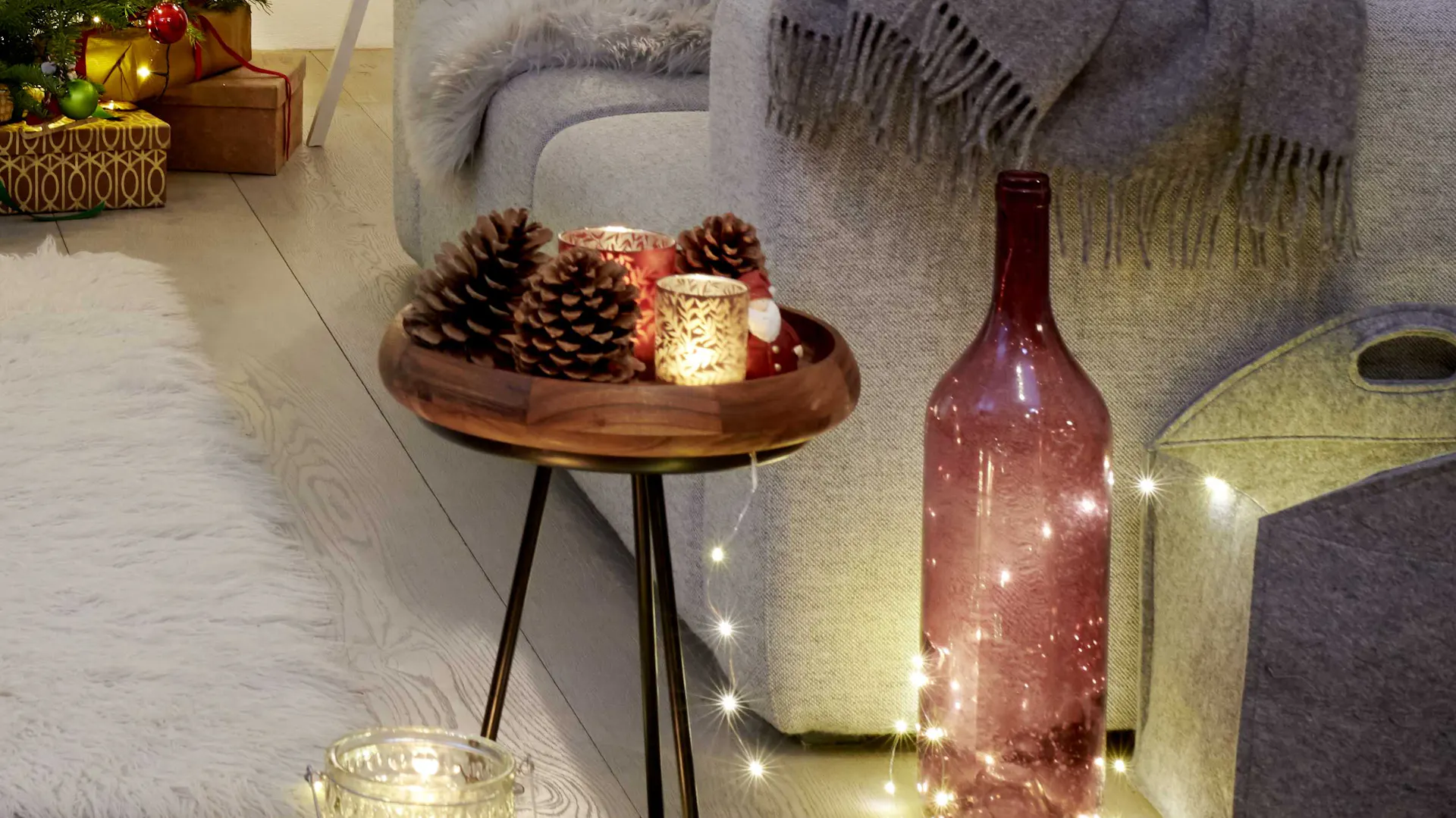 Tavolo da appoggio con lumicino e grandi pigne come decorazione natalizia