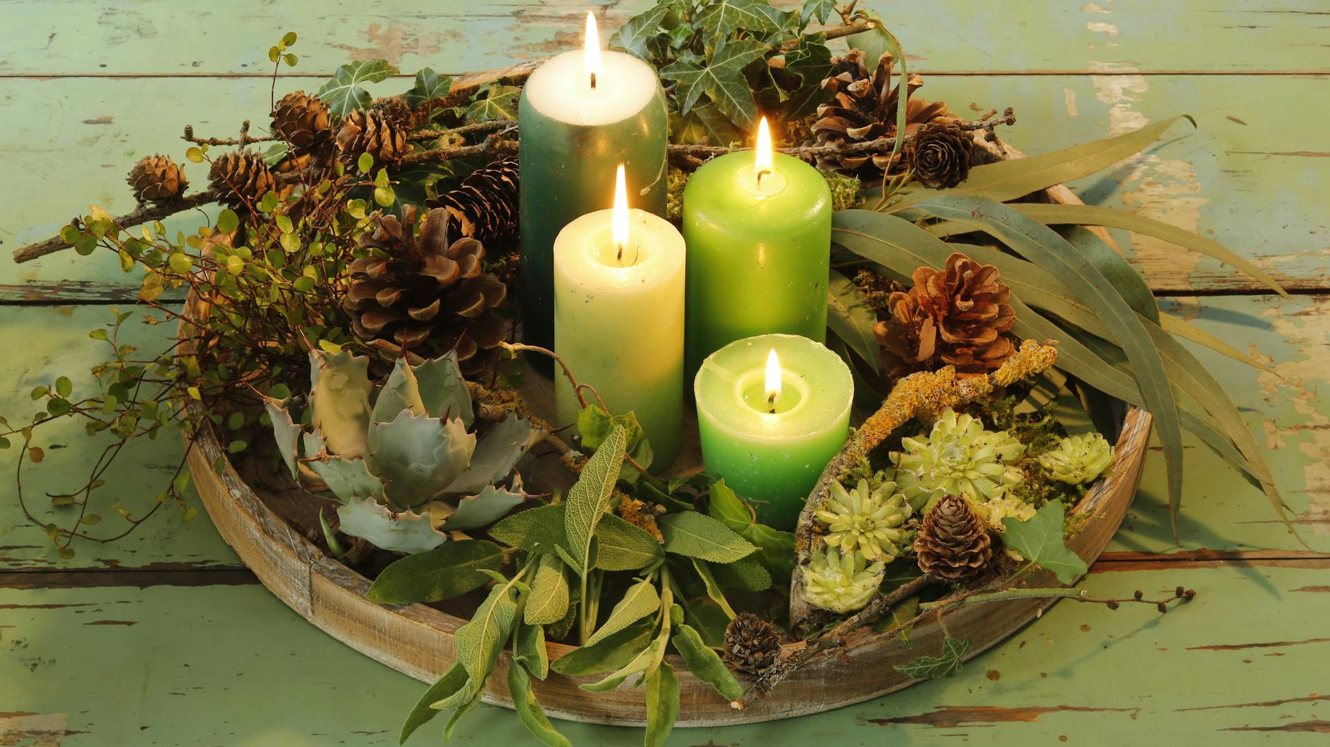 Un piatto decorato con decorazioni natalizie e quattro candele