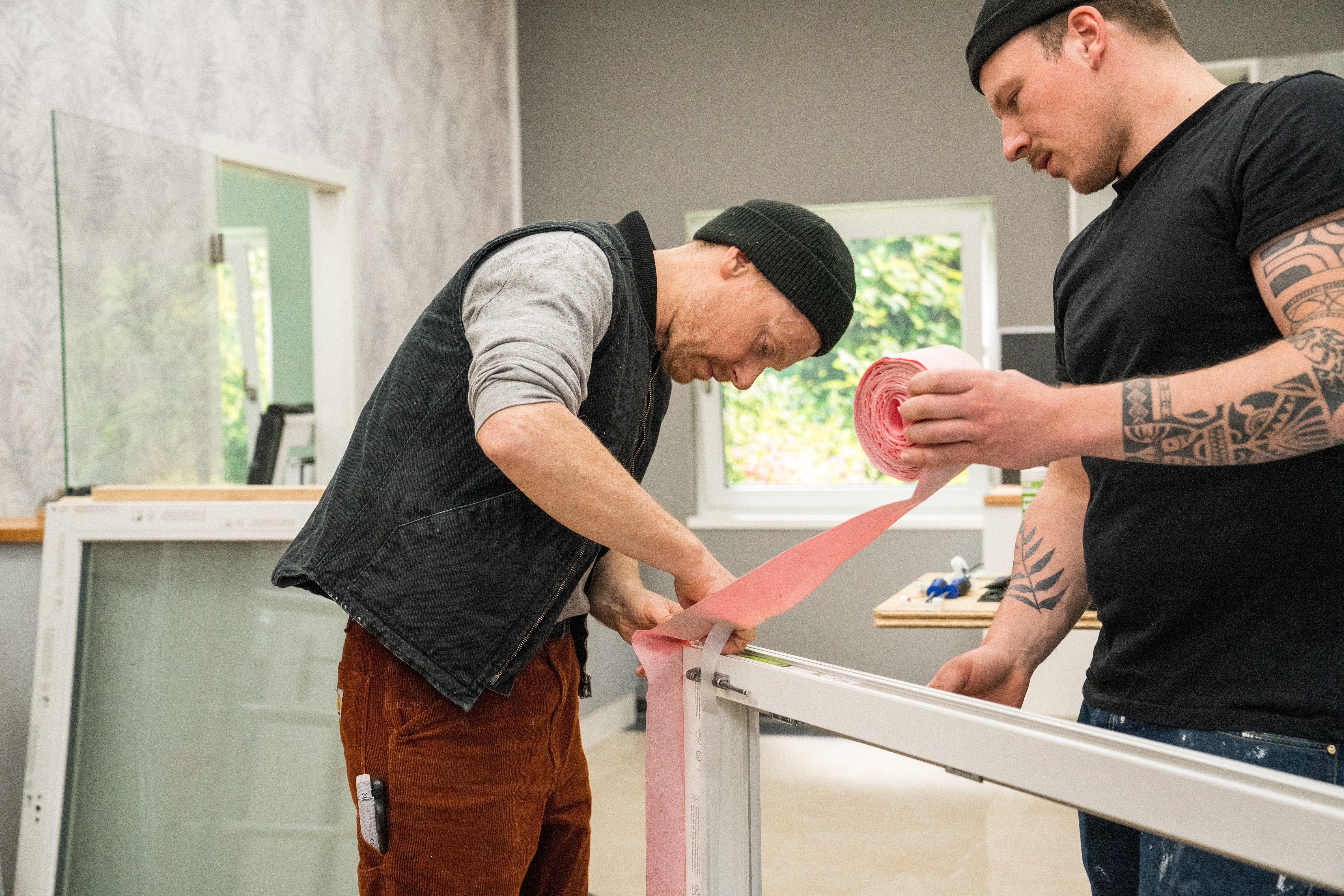 Handwerker bringen Dichtungsbänder an.