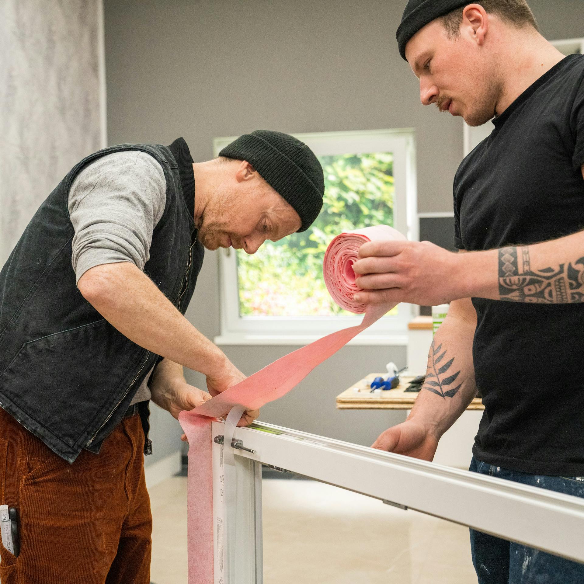 Handwerker bringen Dichtungsbänder an.