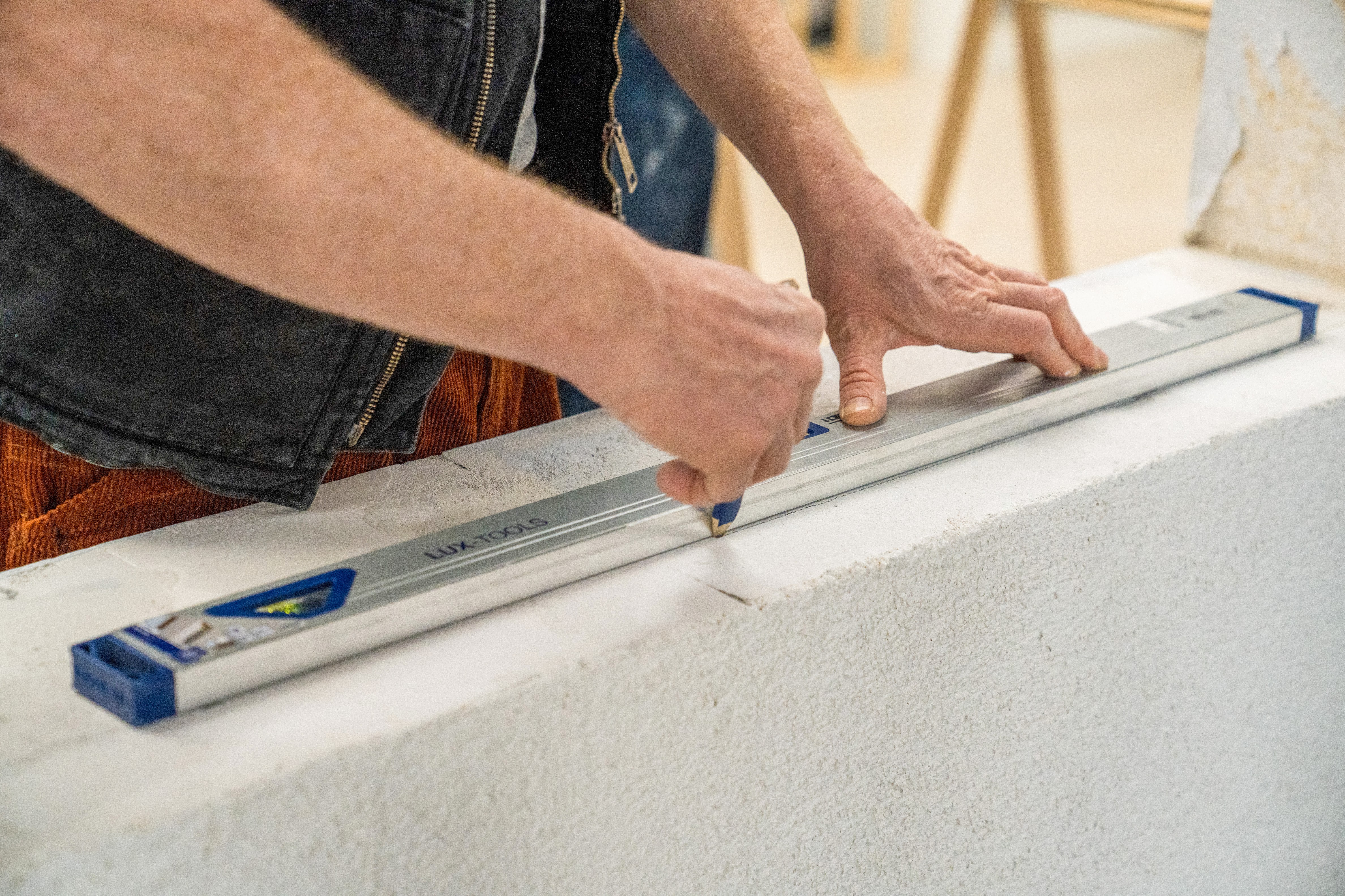 Handwerker markiert die Position des Fensters in der Laibung.