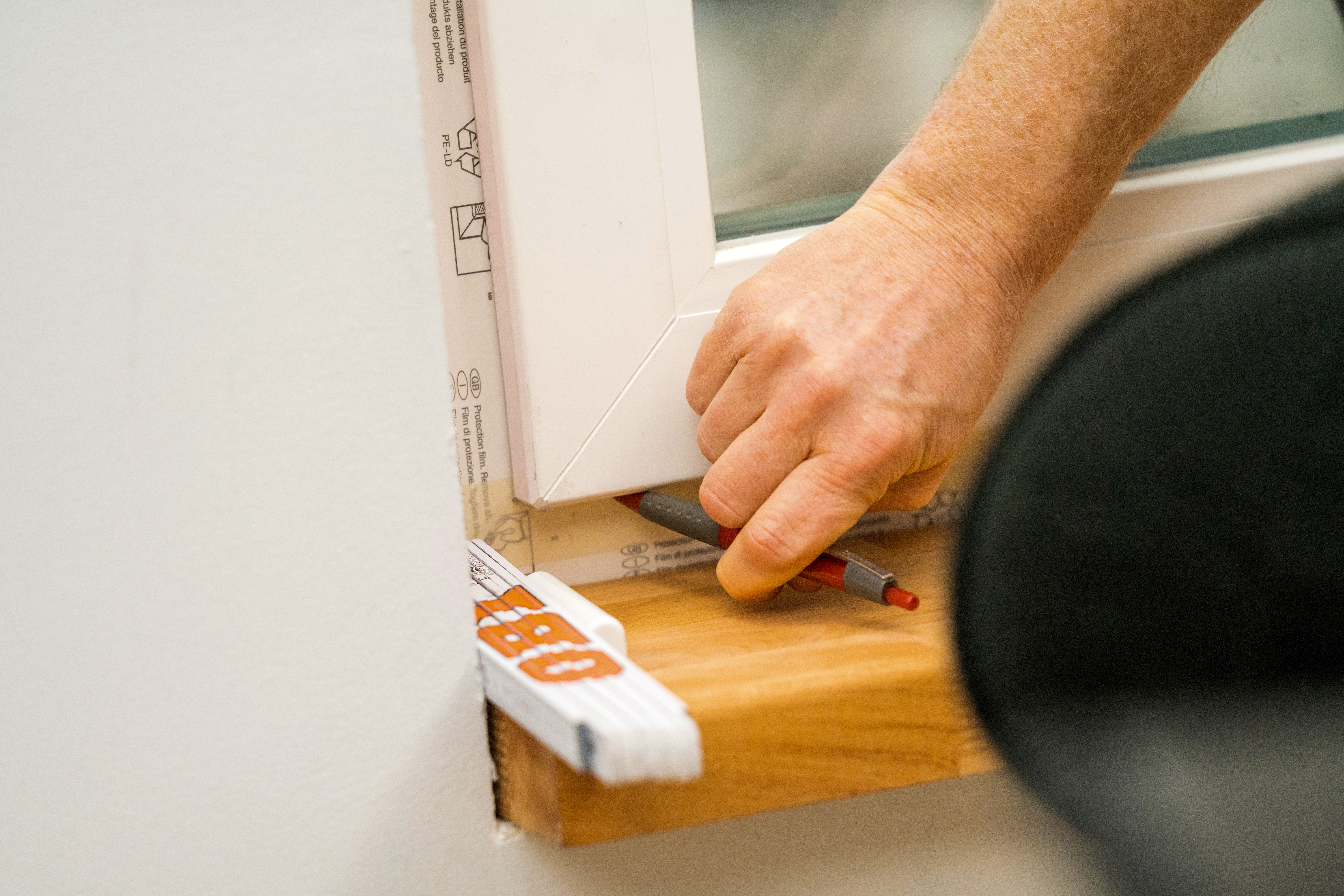 Jemand markiert die Position des Fensterflügels.