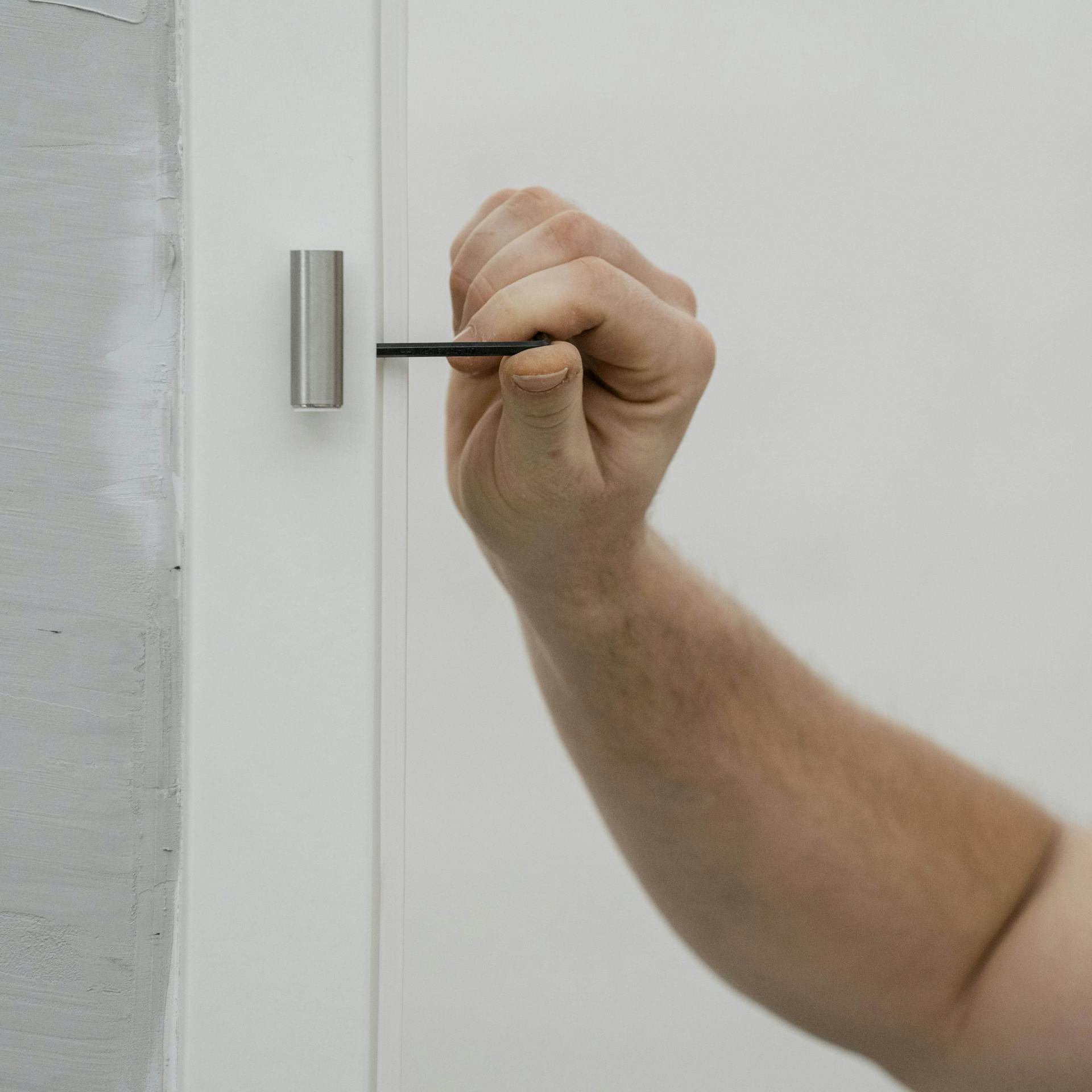 Ein Mann montiert Türbänder an einer Zarge