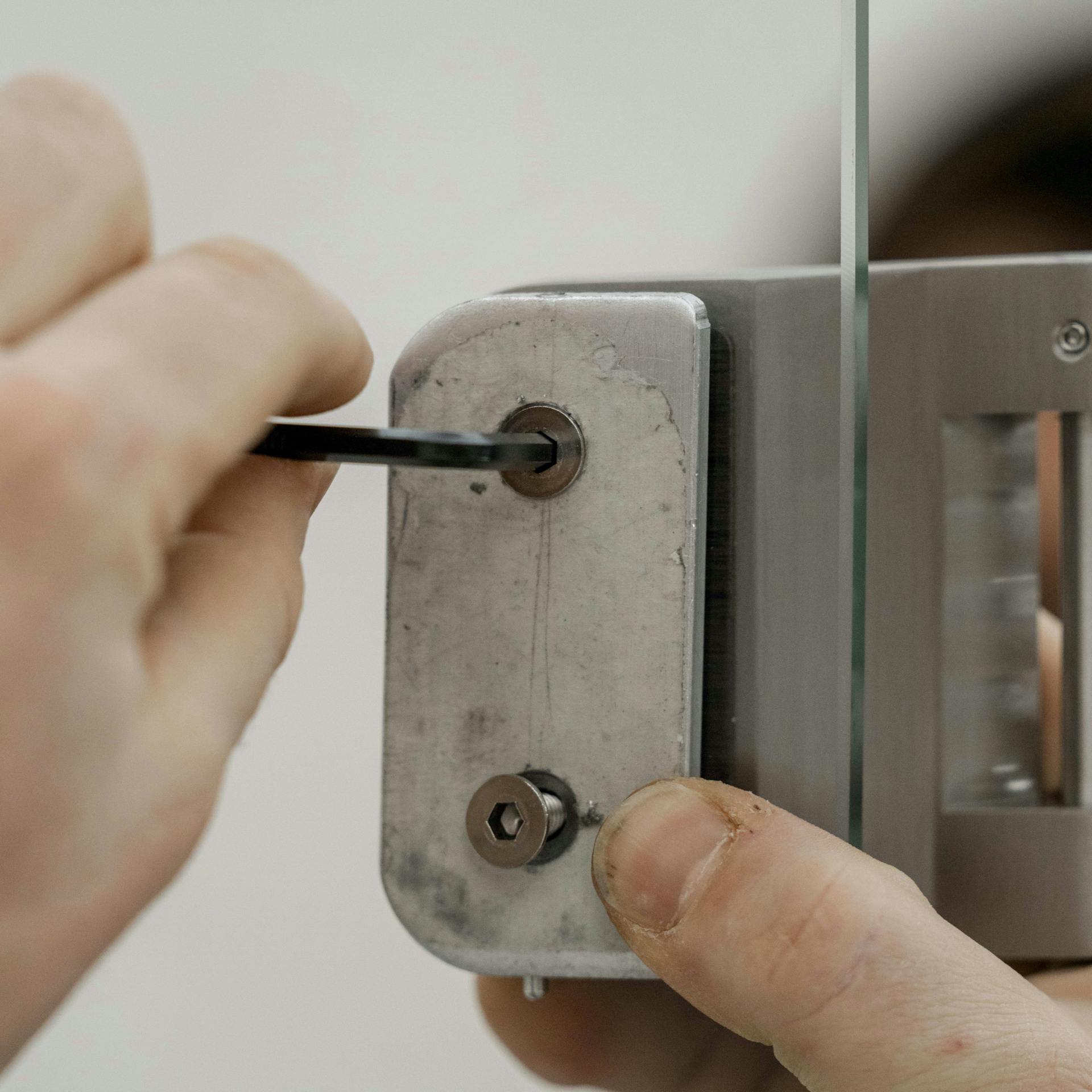 Jemand montiert einen Beschlag an einer Glastür