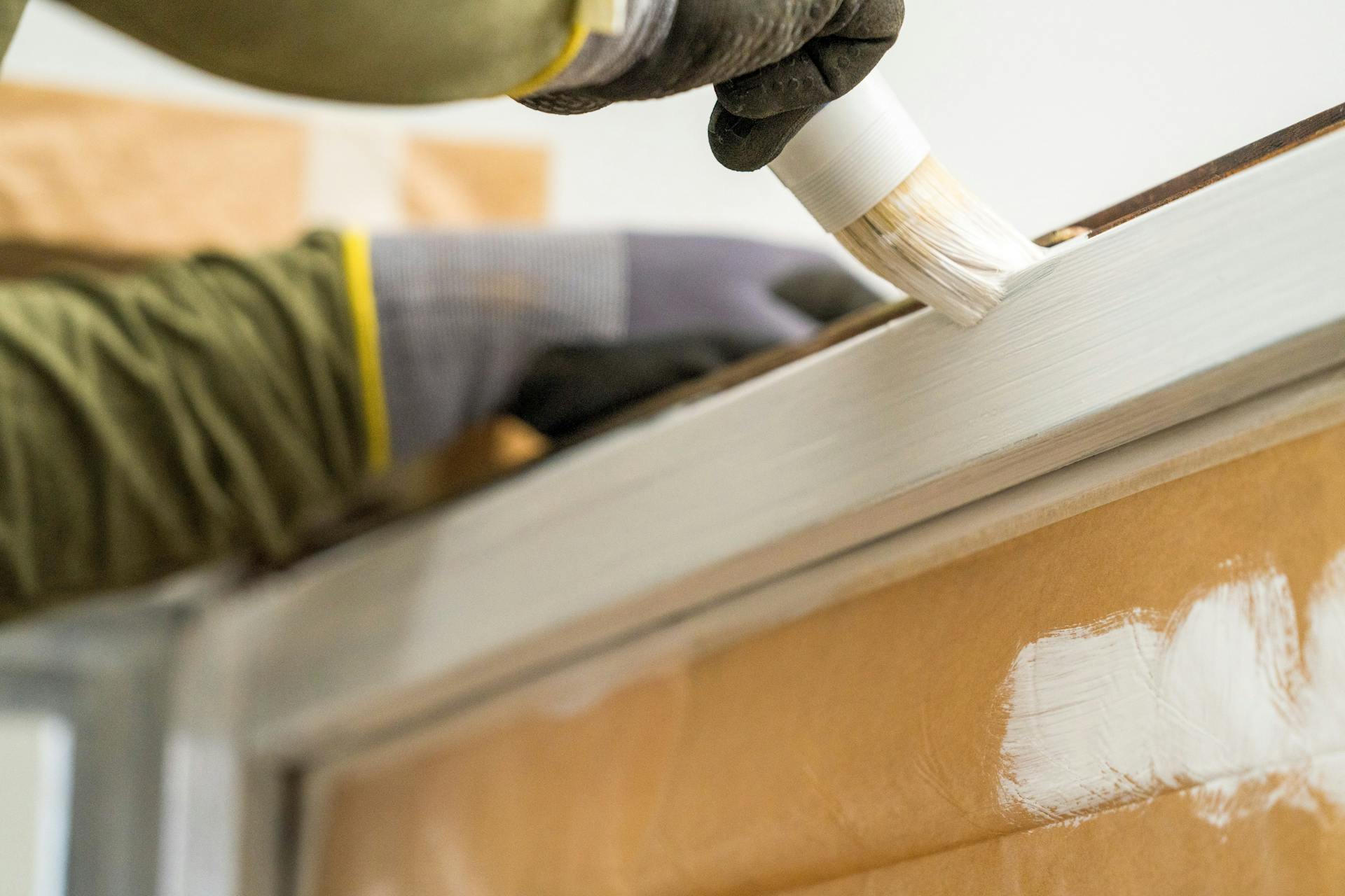 Un amante del fai da te vernicia una finestra con una vernice PU.