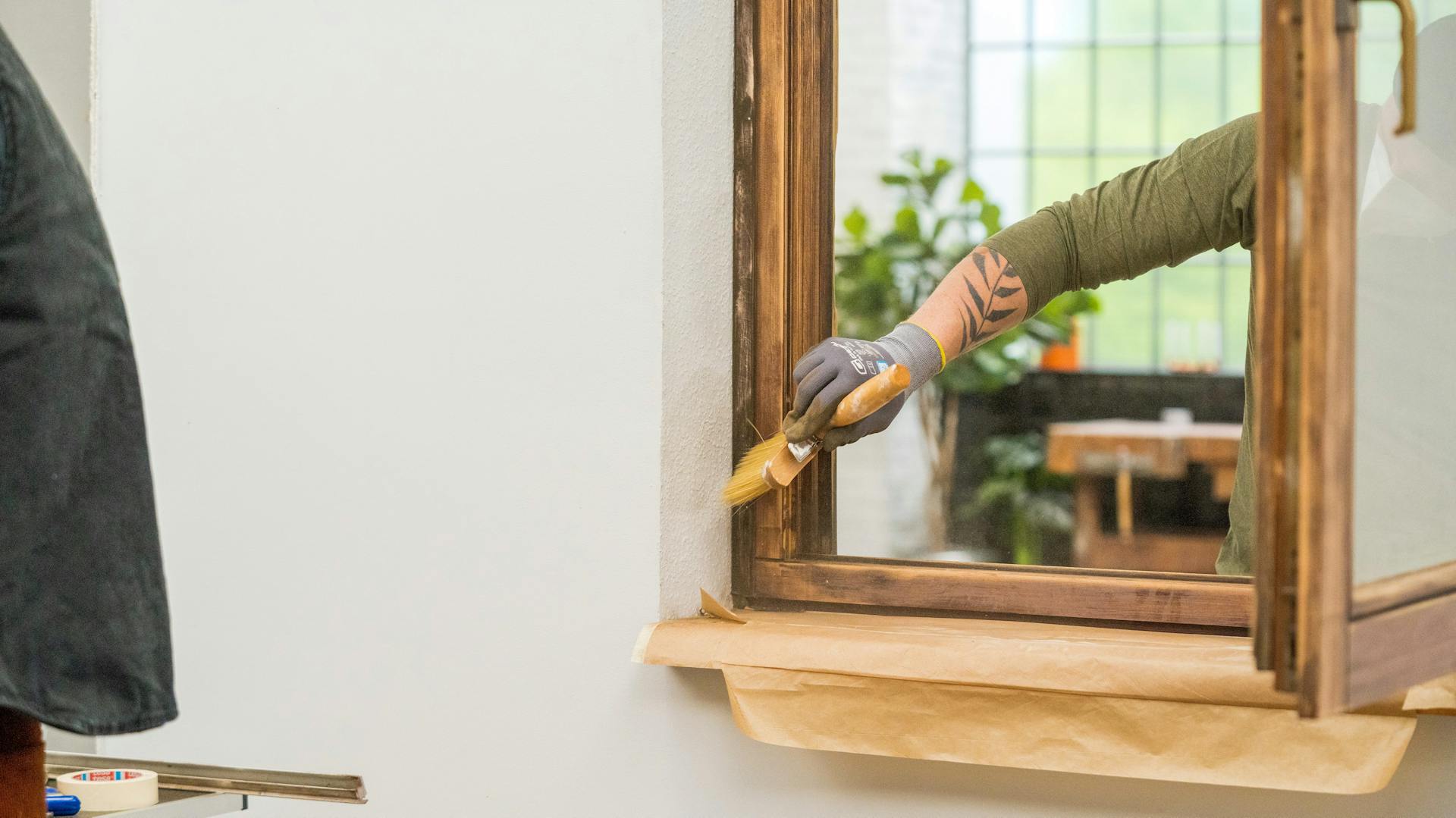 Appassionato di fai da te dipinge una finestra in legno