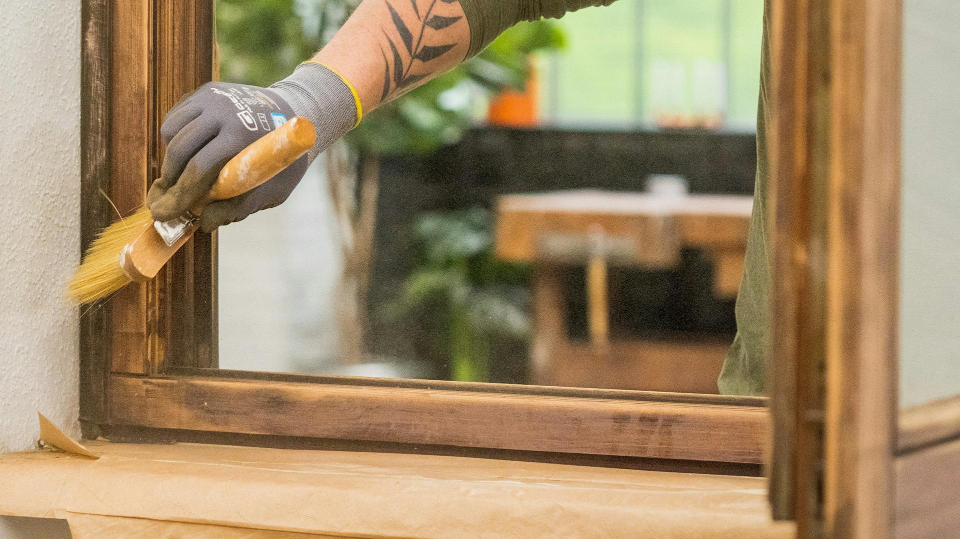Heimwerker streicht ein Holzfenster