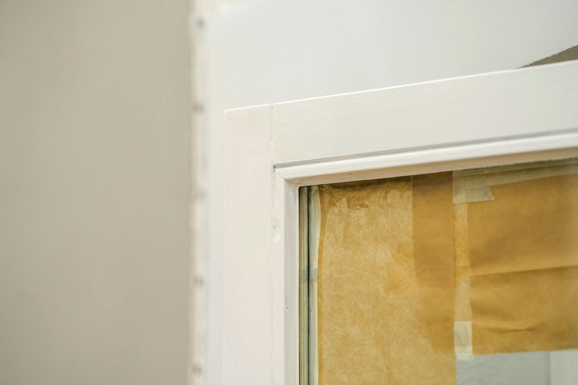 Vernice bianca sul telaio di una finestra in legno.