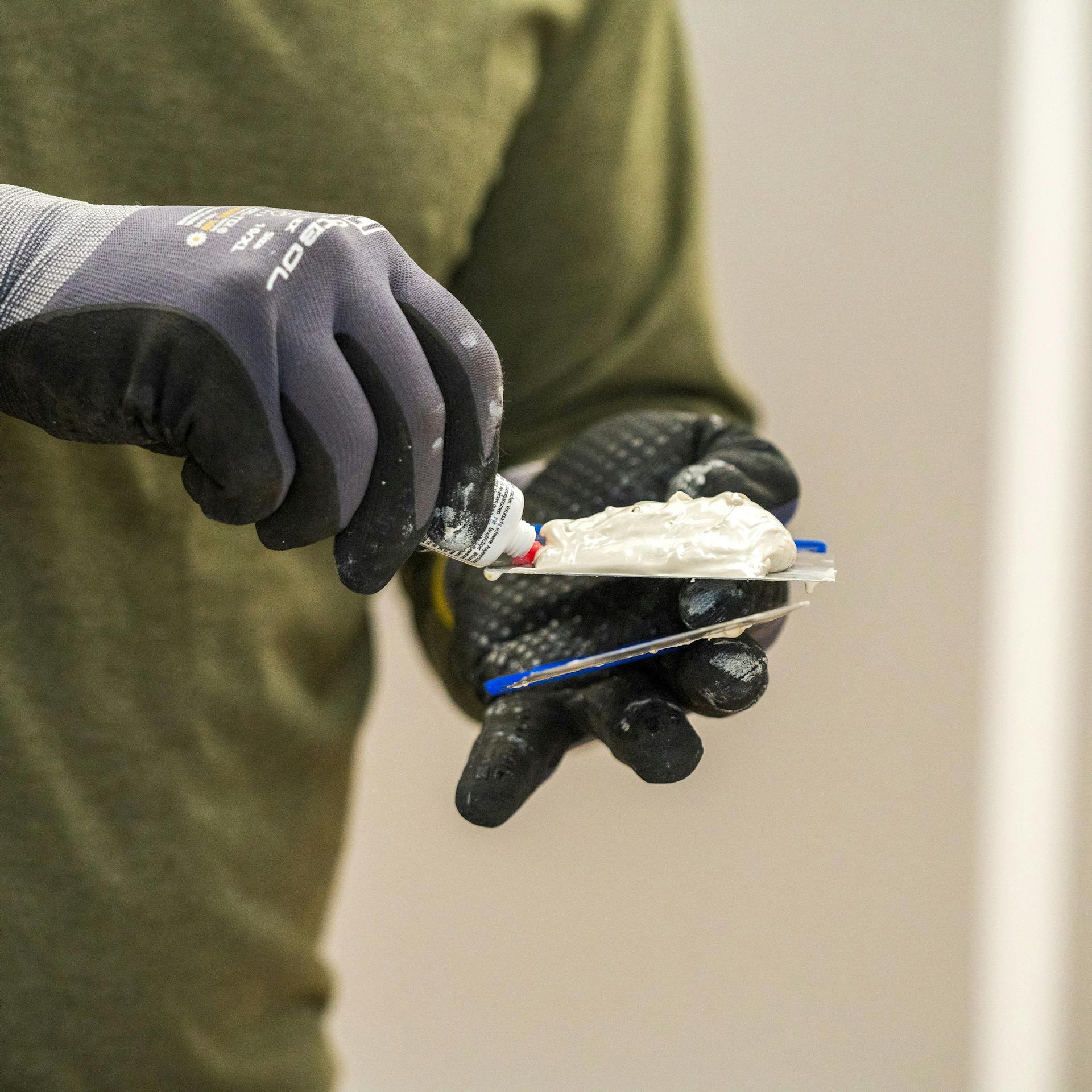 Heimwerker rührt Spachtelmasse an.