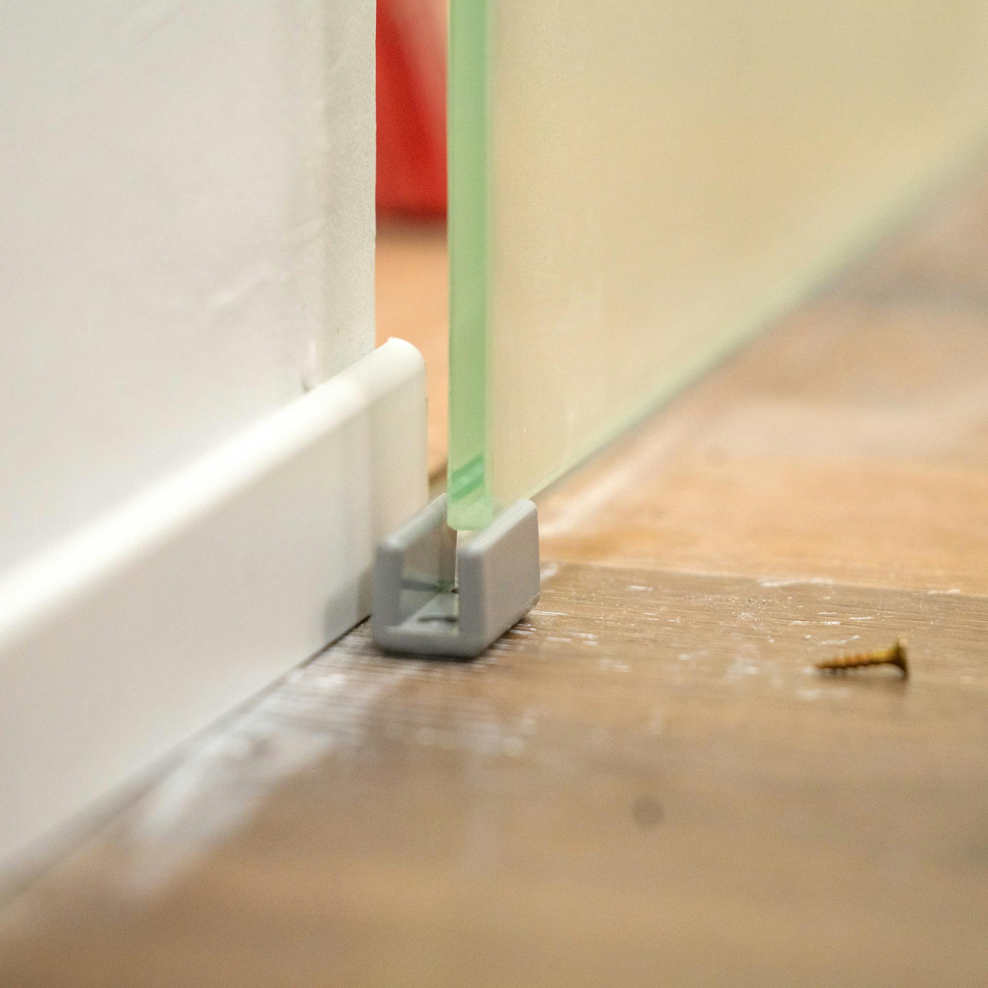 Handwerker bringt Fußleiste für Schiebetür an.