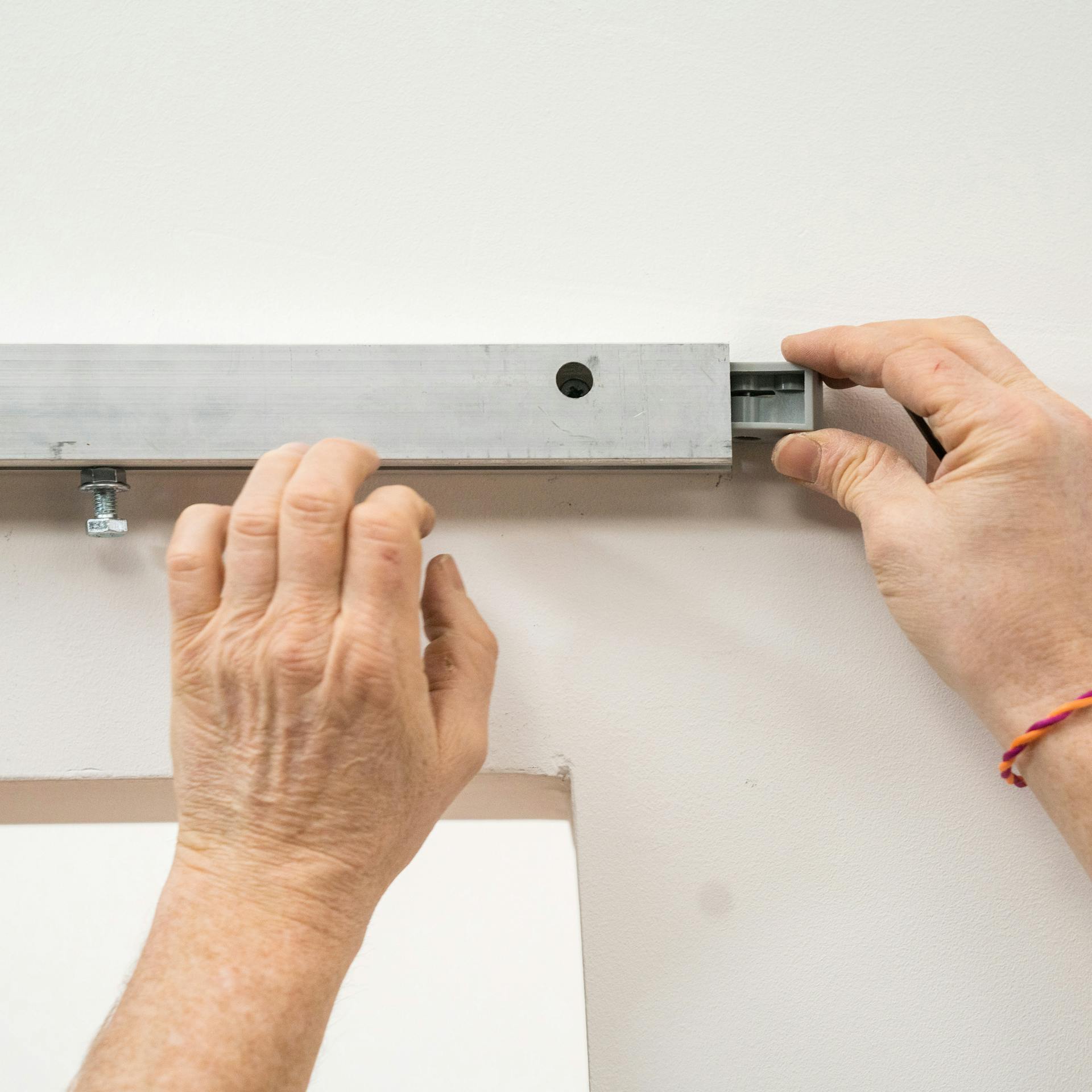 Handwerker bringt die Laufteile der Tür in die Laufschiene an.