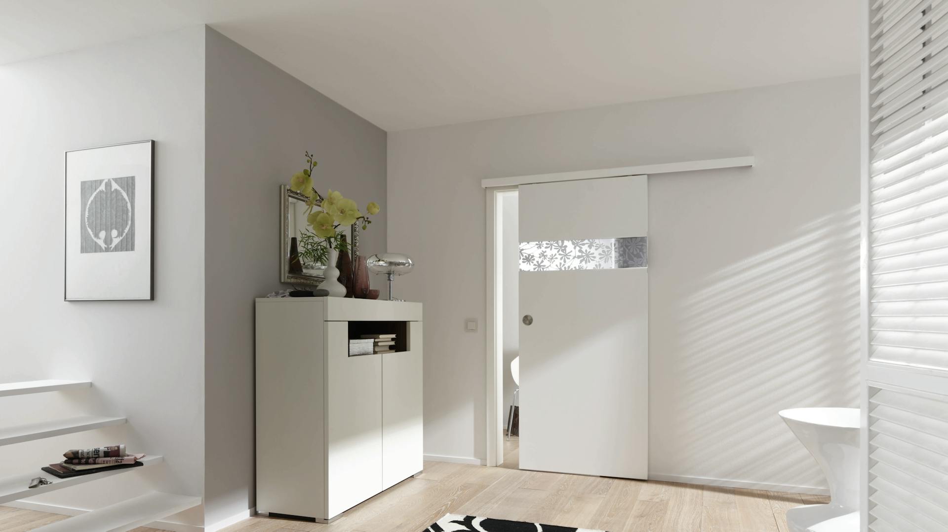 Schiebetür bauen für einen Wohnraum mit Kommode, Teppich und Treppenaufgang.