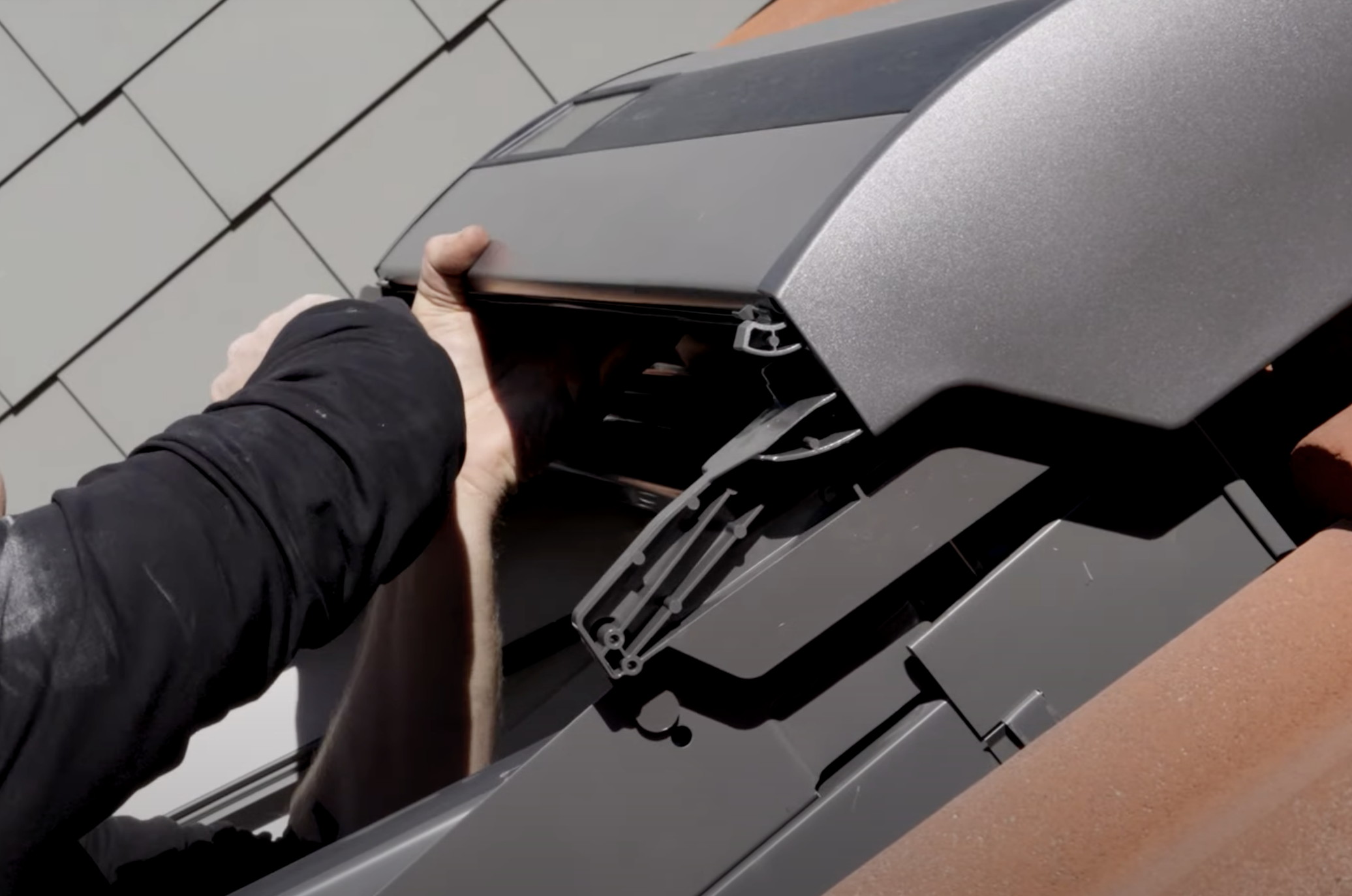 Ein Mann setzt den Solar-Rolladenkasten ein.