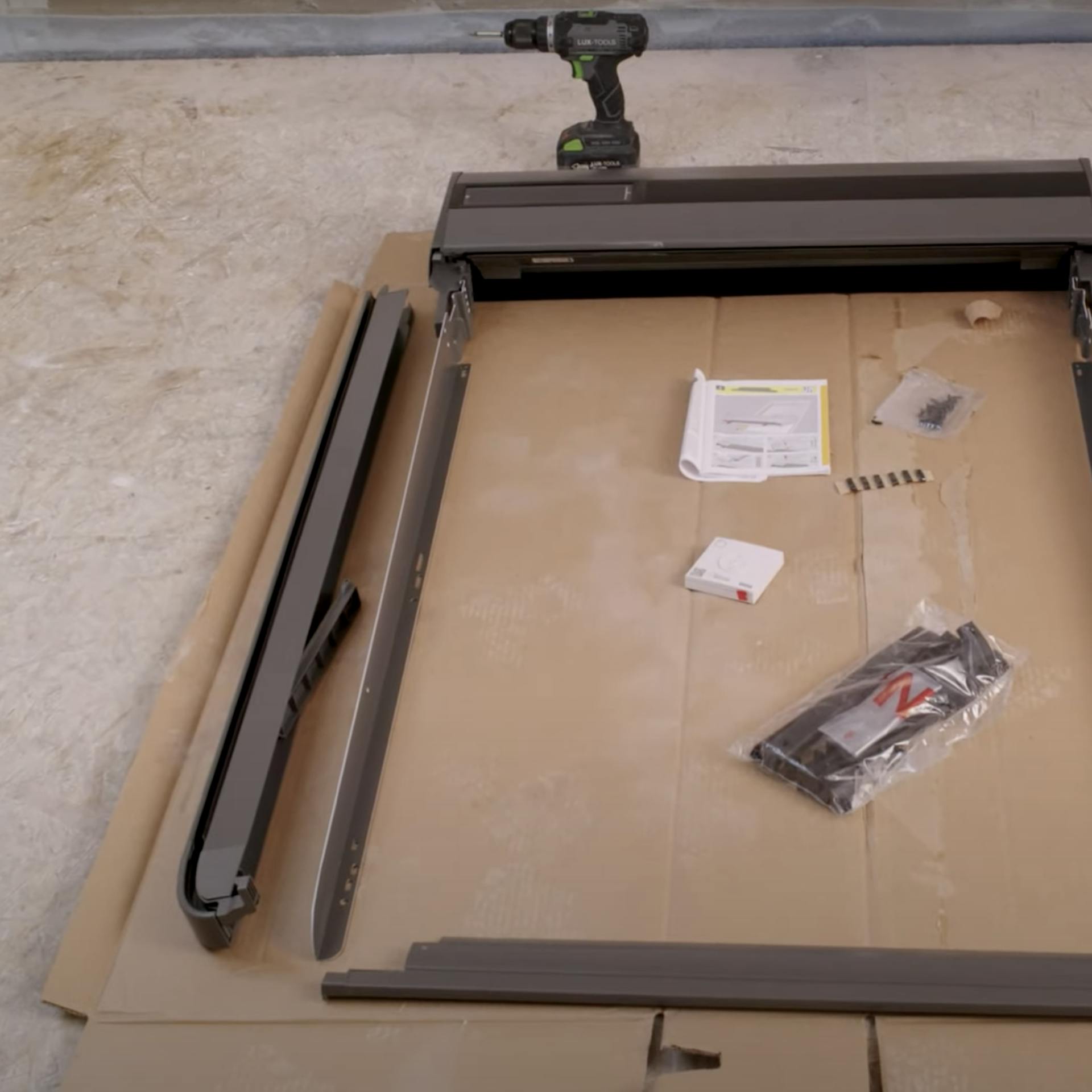 Ein Mann setzt einen Rolladenkasten ein.