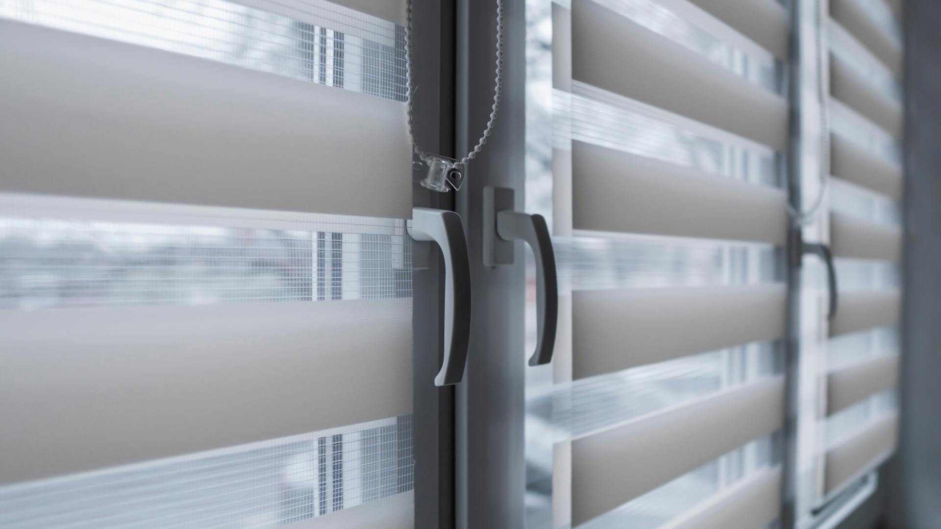 Es ist eine Reihe von Fenstern zu sehen. Vor den einzelnen Fenstern hängen halbtransparente Vorhänge.