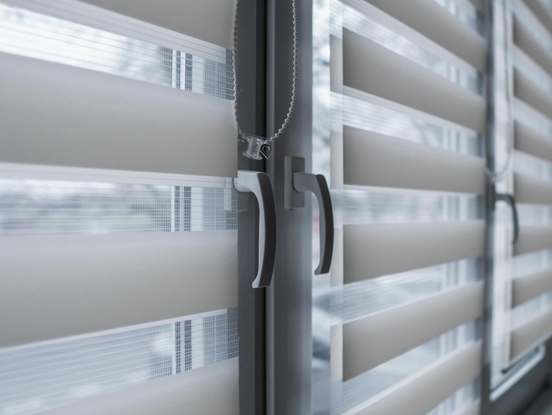 Serie di finestre. Davanti alle singole finestre sono appese tende semitrasparenti.