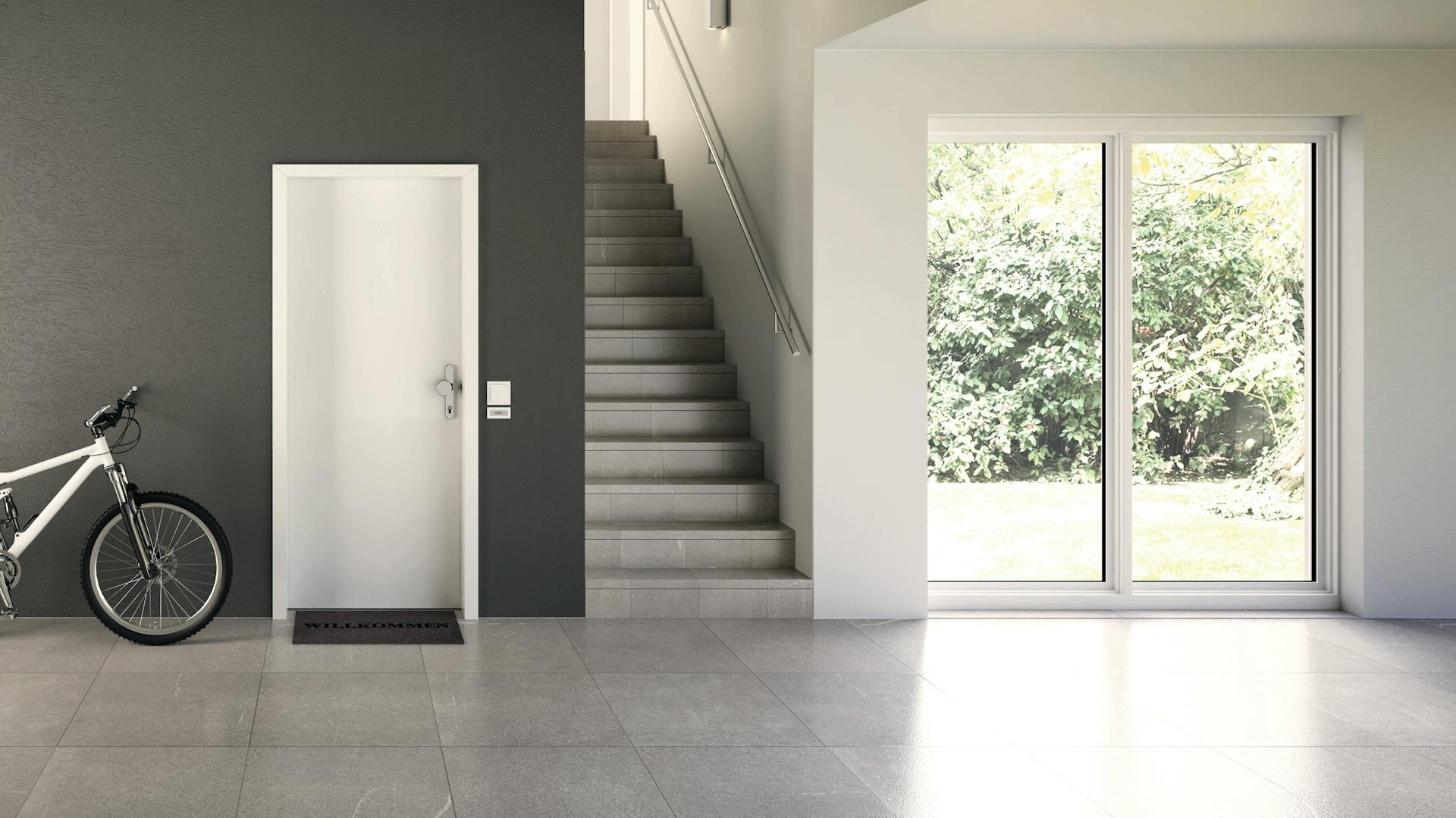 Ein Neubau mit weißer Tür und Terrassentüren mit Fenstern