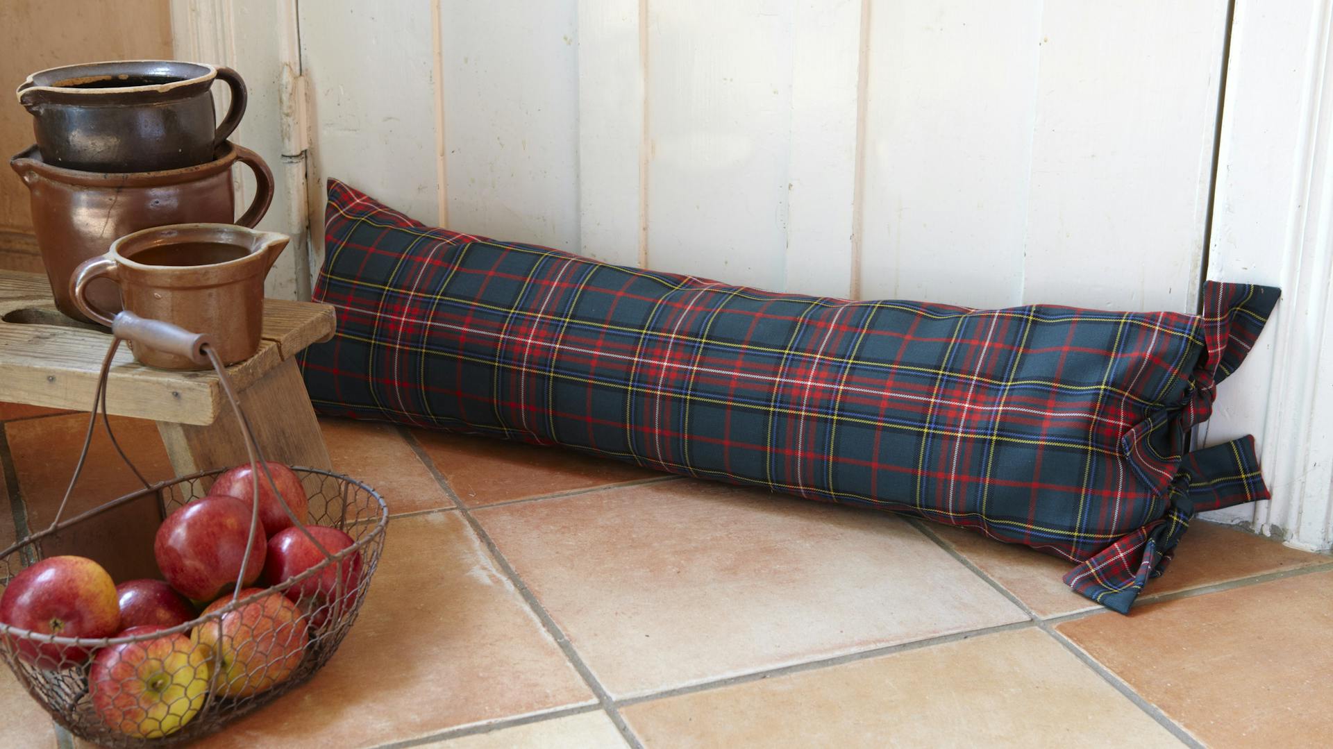 Szövet ajtószigetelő párna egy szobaajtó előtt