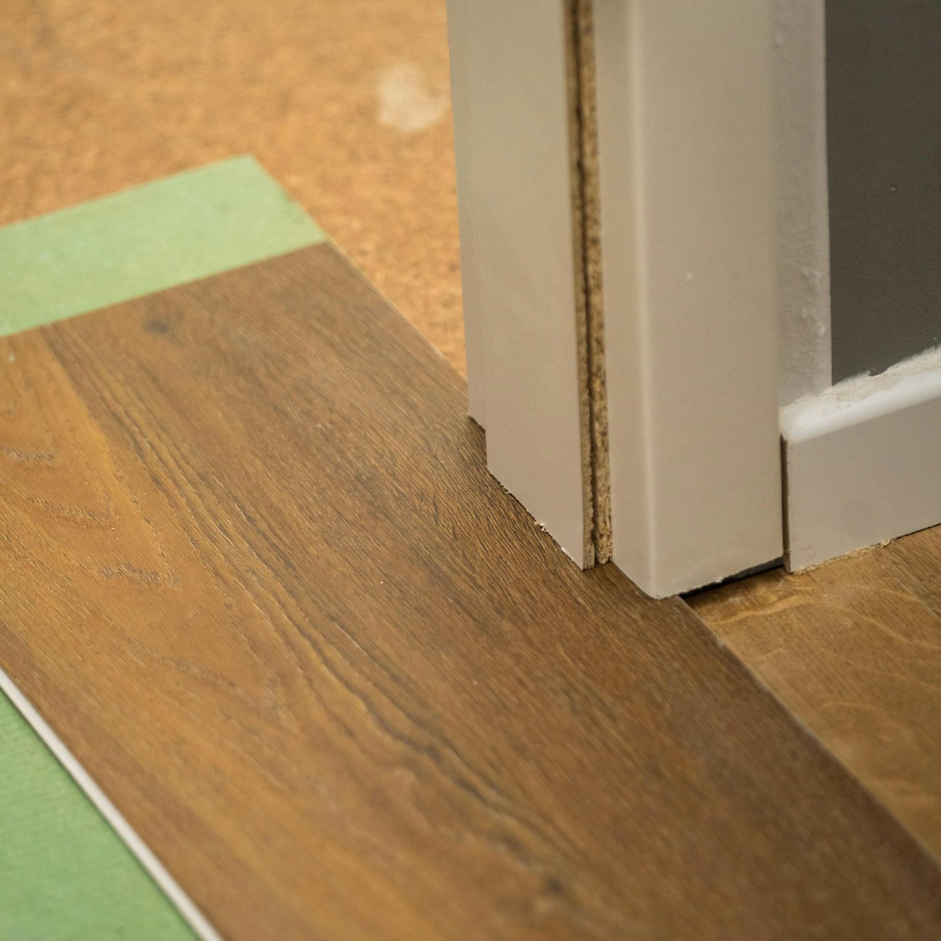 Neuer Bodenbelag und Trittschalldämmung unter gekürzter Türzarge.