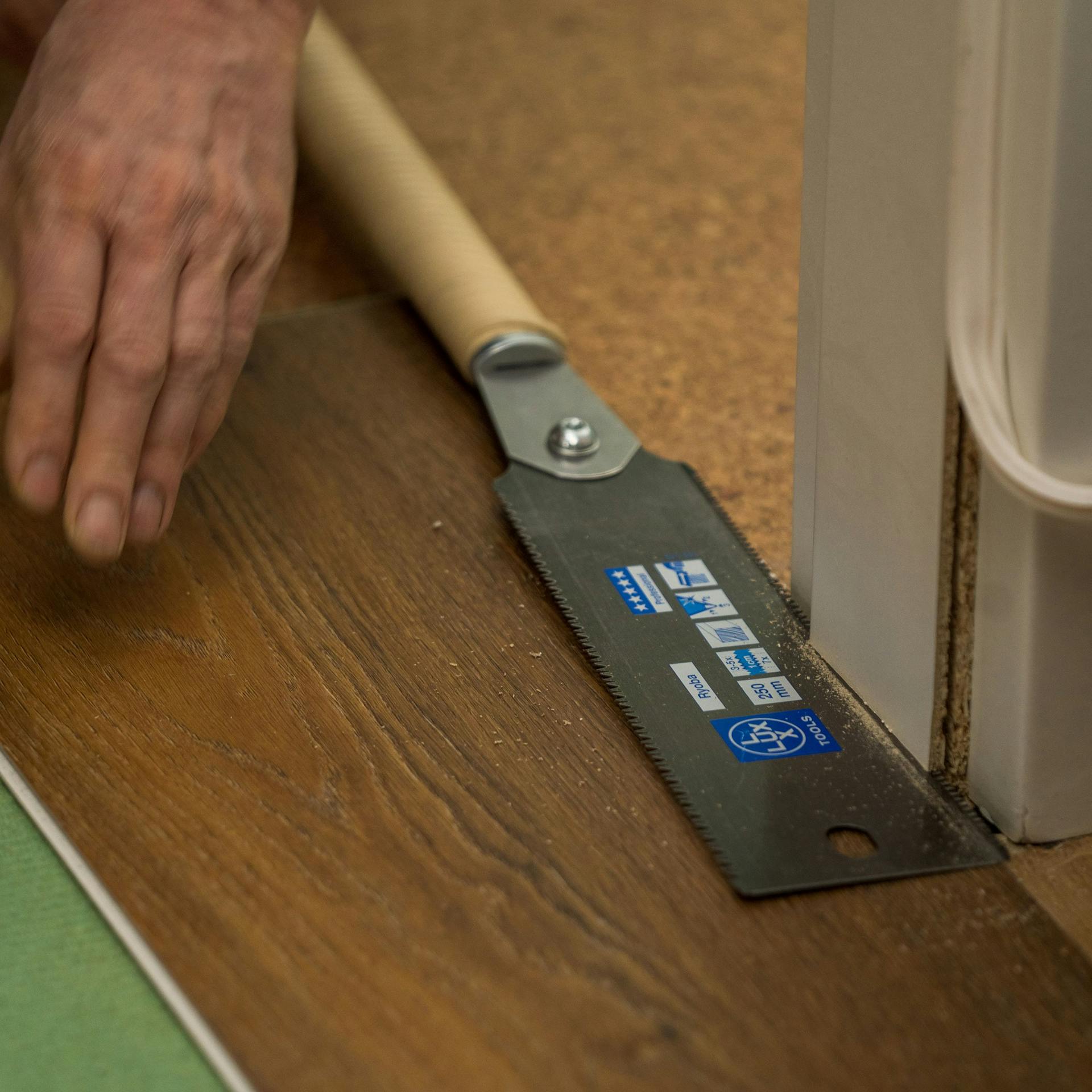 Ein neuer Bodenbelag dient als Schnittführung beim Einkürzen einer Türzarge.