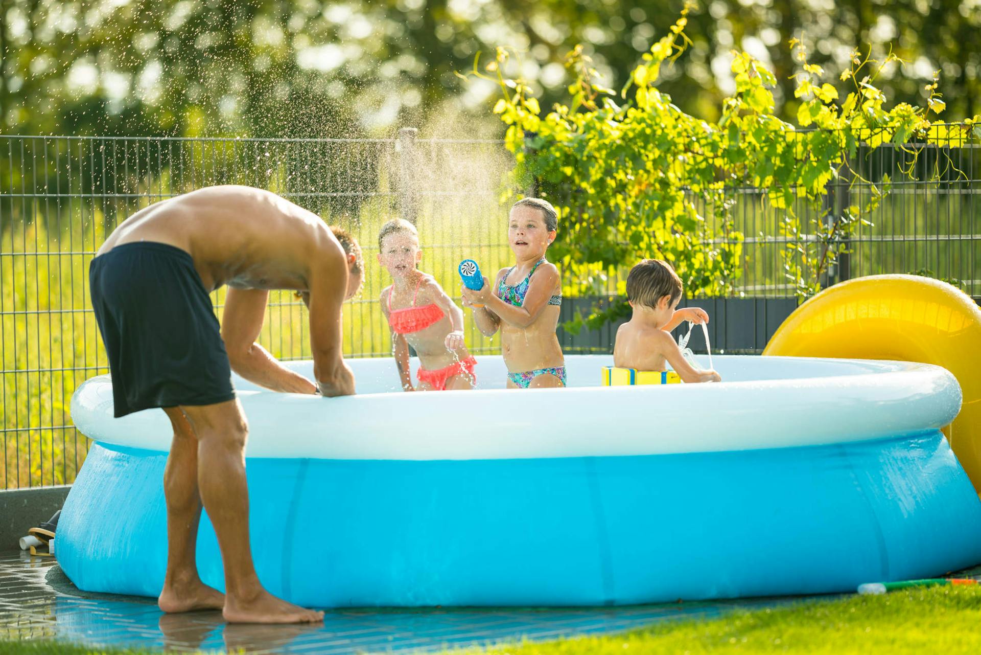 I bambini giocano in una piscina Fast Set con il papà vicino.