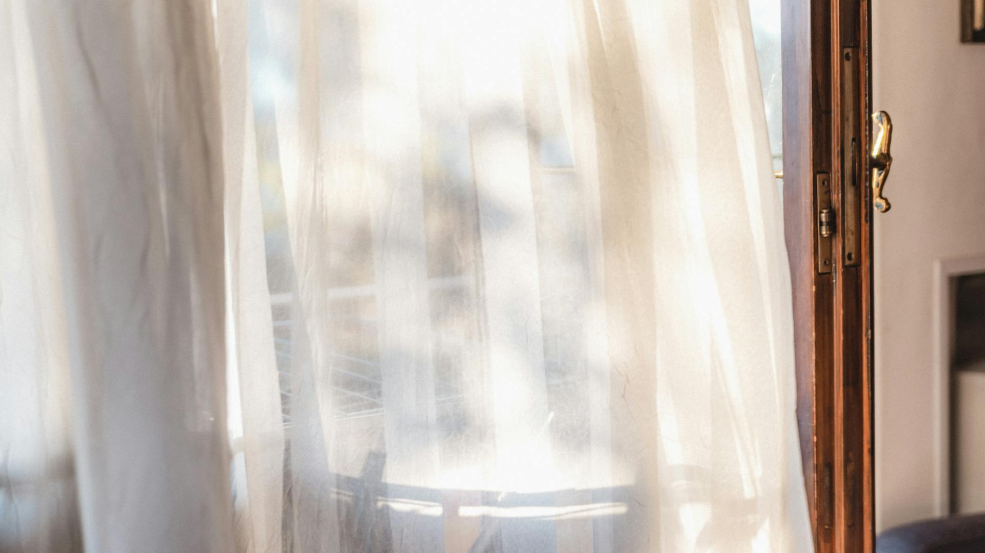 Wind weht durch einen Vorhang in der Morgensonne