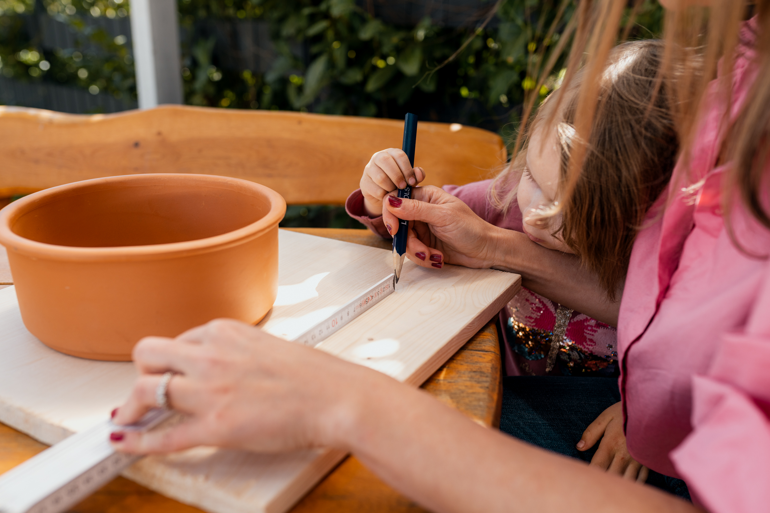Donna disegna un modello con una matita su un pannello di legno