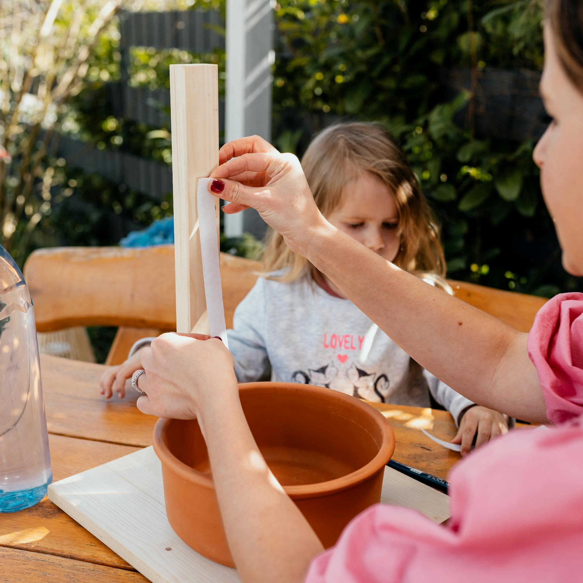 Frau klebt selbstklebendes Klettband an eine Holzlatte
