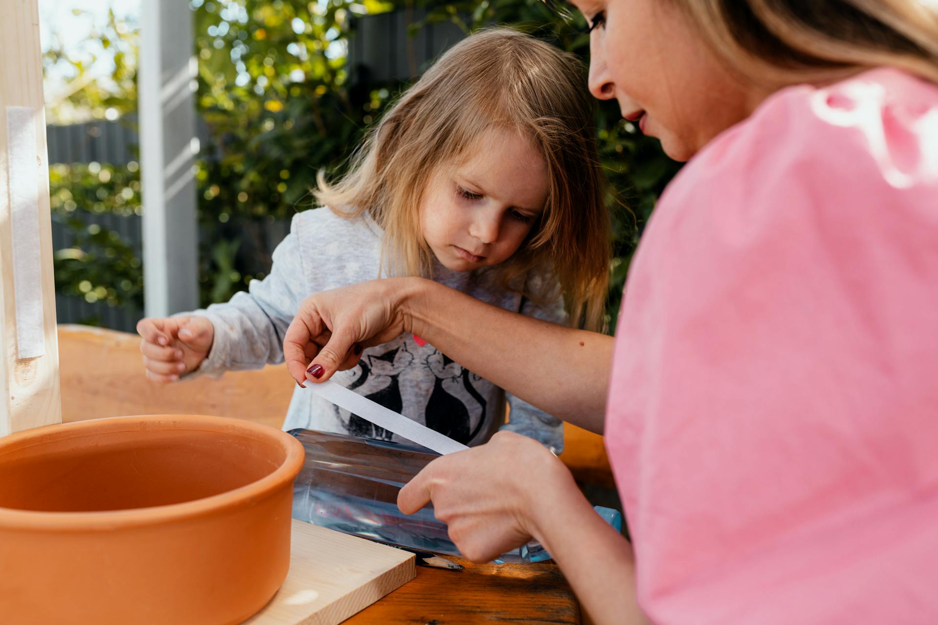 Donna applica del velcro autoadesivo su una bottiglia vuota