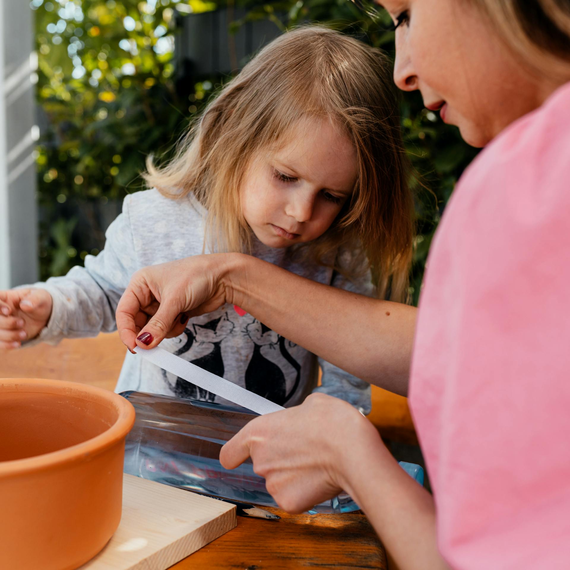 Frau klebt selbstklebendes Klettband an eine leere Flasche