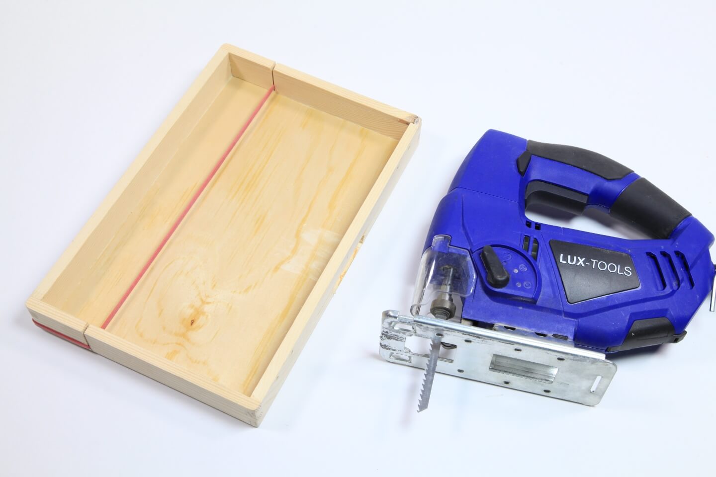 Stichsäge liegt neben Deckel aus Holz