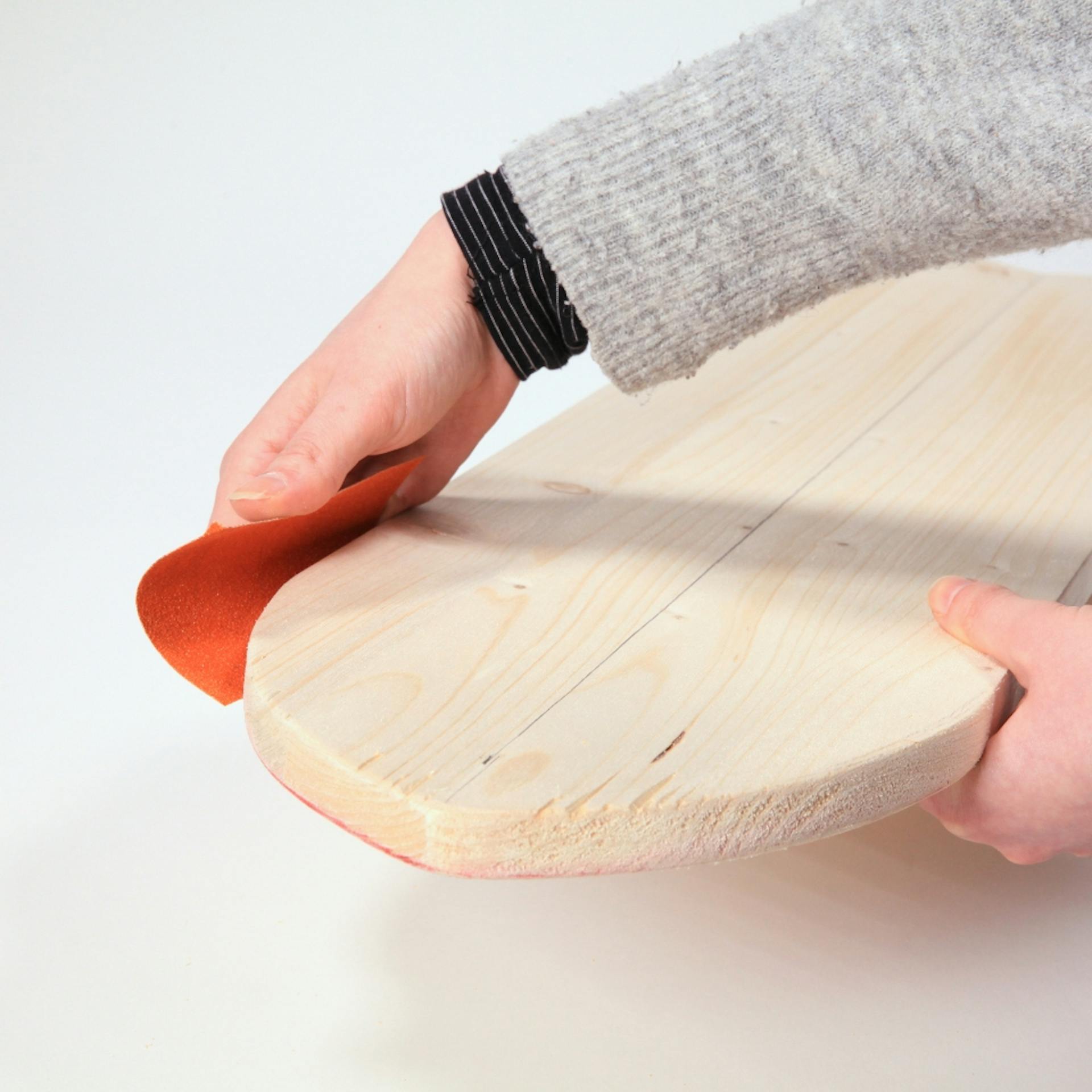 Person schleift Kanten des Balance Boards.