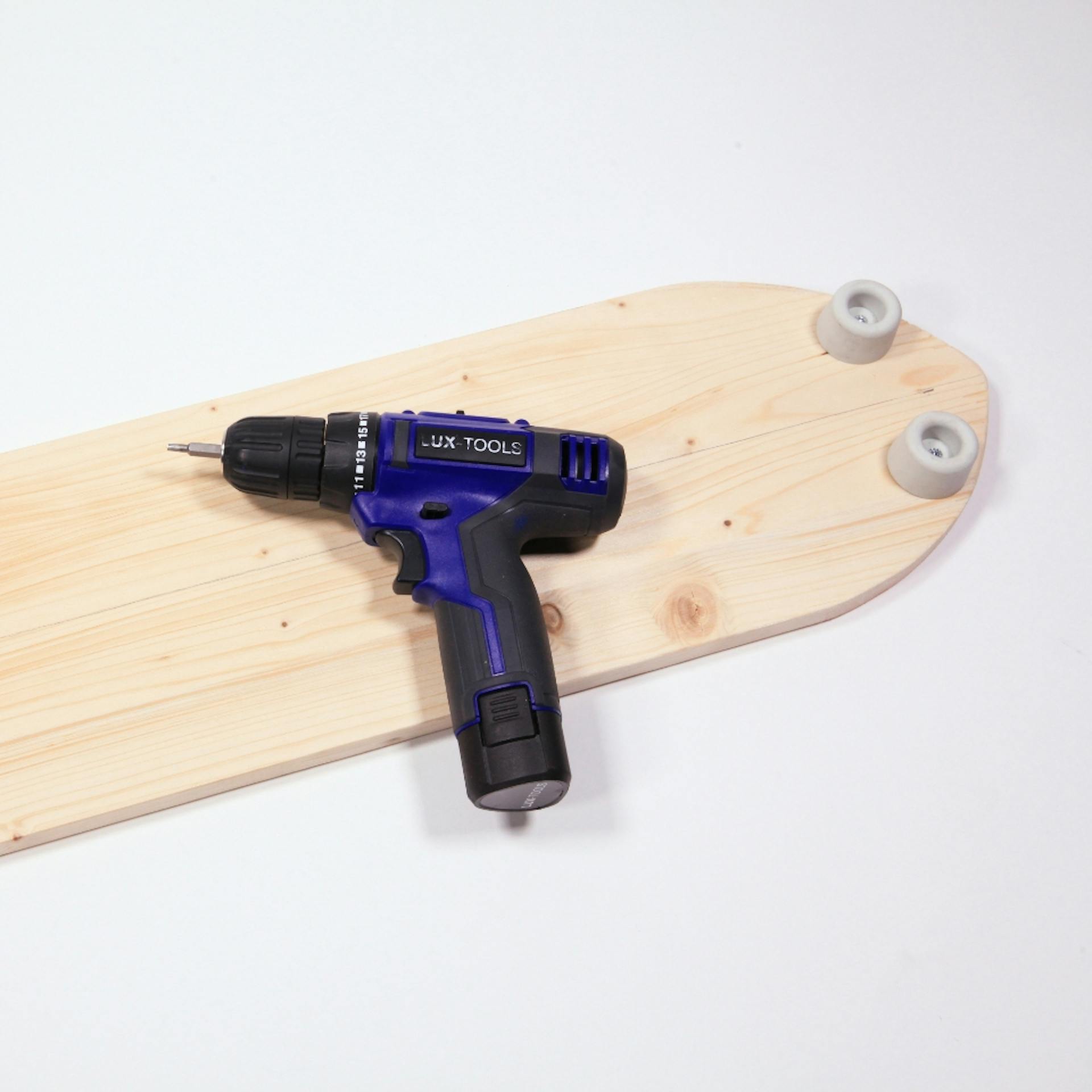 Balance Board mit Türstoppern, darauf liegt ein Akkuschrauber.