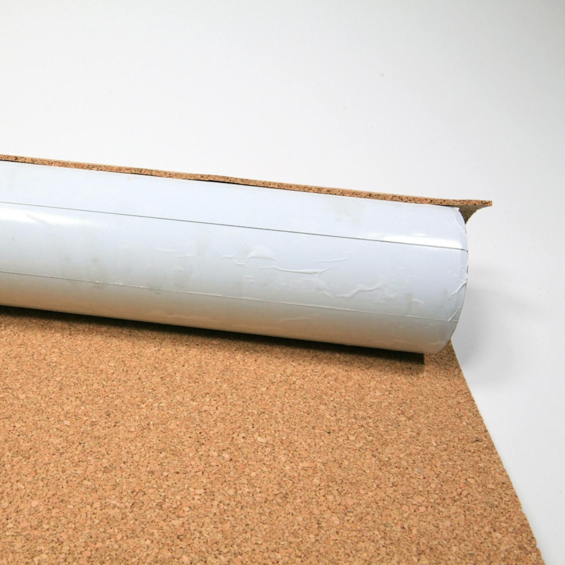 Mit Klebeband umwickeltes Rohr wird mit Korkplatte umwickelt.