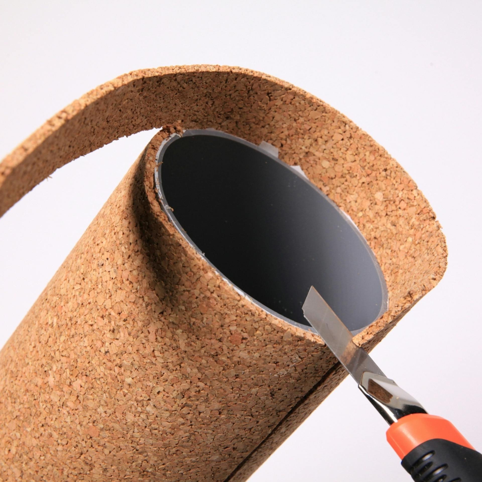 Von einem Rohr abstehender Kork wird mit Cutter abgeschnitten.