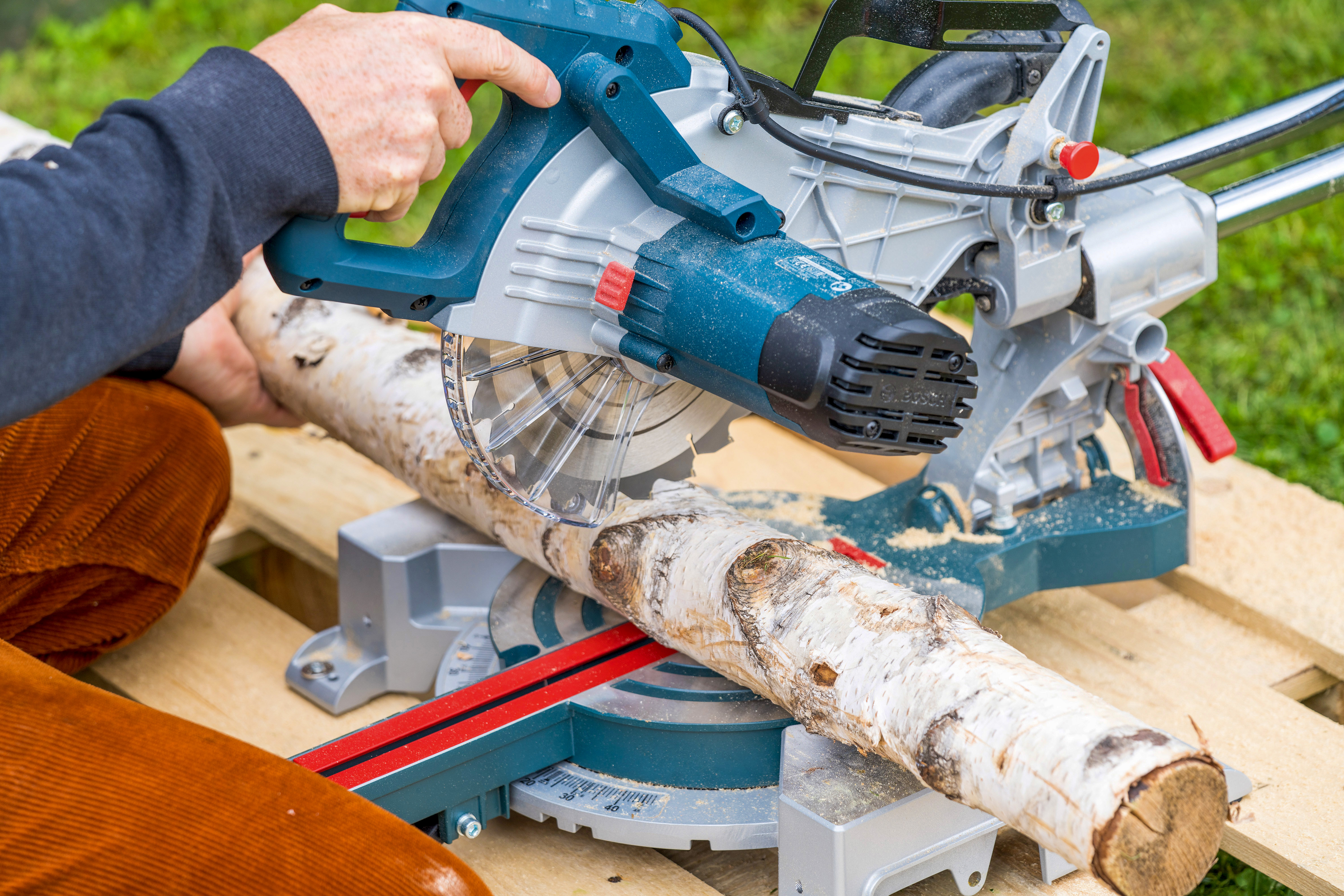 Birkenstamm wird zum Befüllen des Barfußpfades zugeschnitten