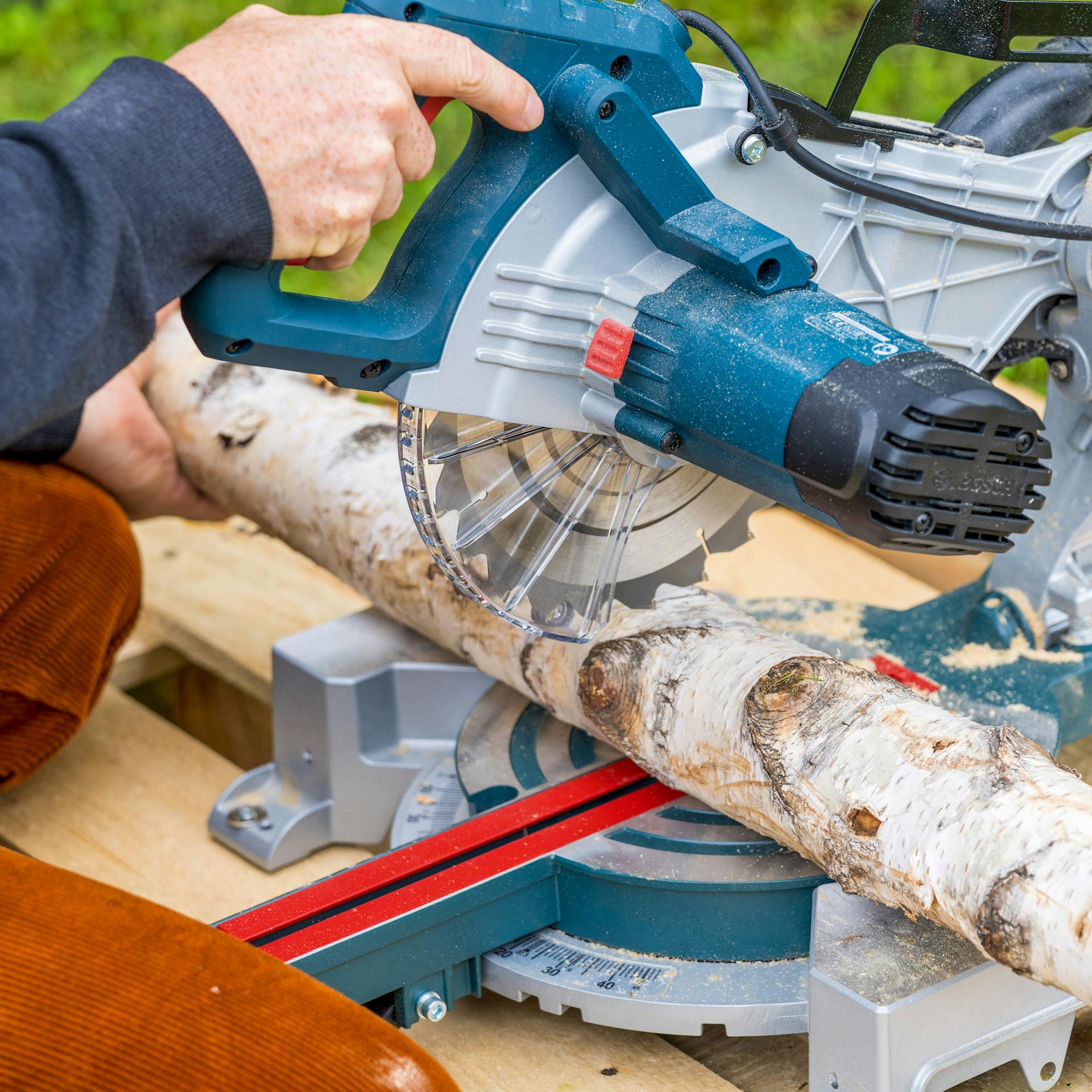 Birkenstamm wird zum Befüllen des Barfußpfades zugeschnitten